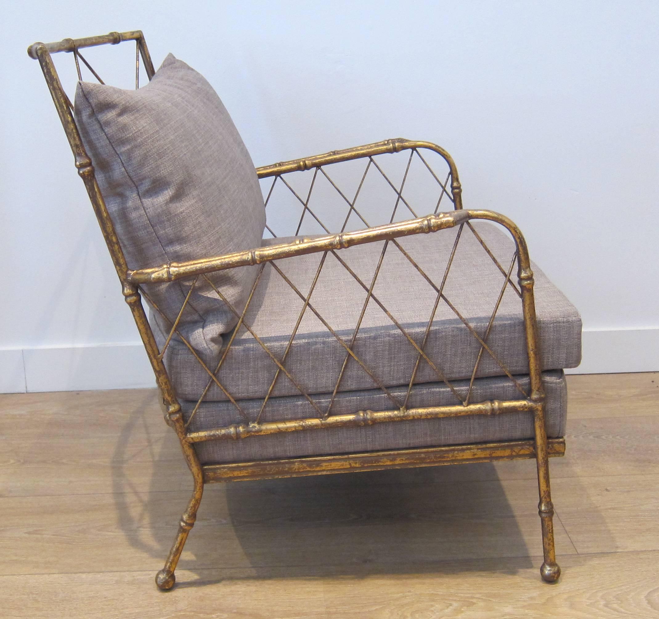 Pair of mid-century modern style gilt metal faux bamboo lounge chairs in the style of Jean Royere. Upholstered with grey linen. 
