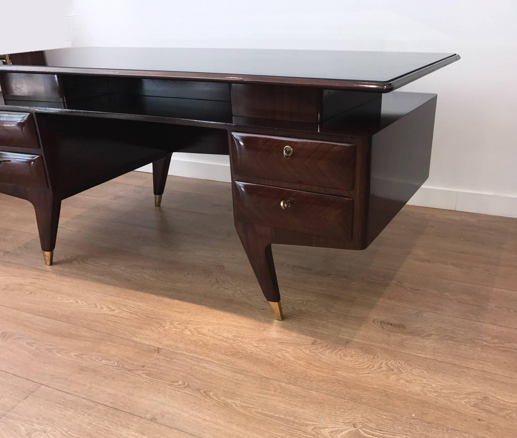 Mid-century modern Italian rosewood executive desk with inset black glass top floating on four-drawer double pedestal attributed to Osvaldo Borsani.
Newly restored to almost perfect condition.