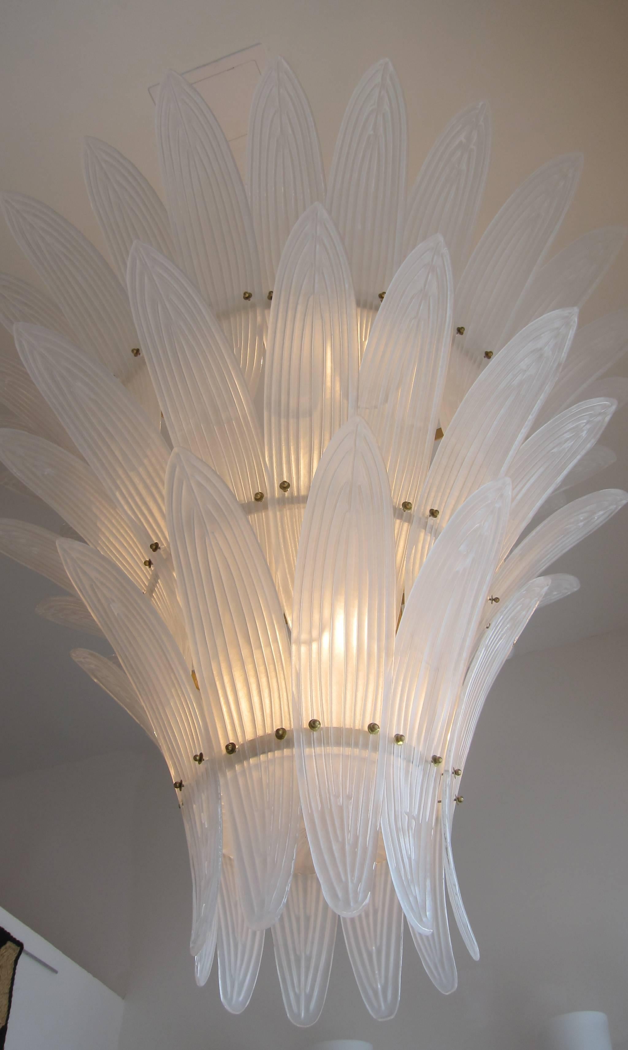 A monumental three-tier hand blown textured palm leaves Murano glass chandelier in the Hollywood Regency style.

