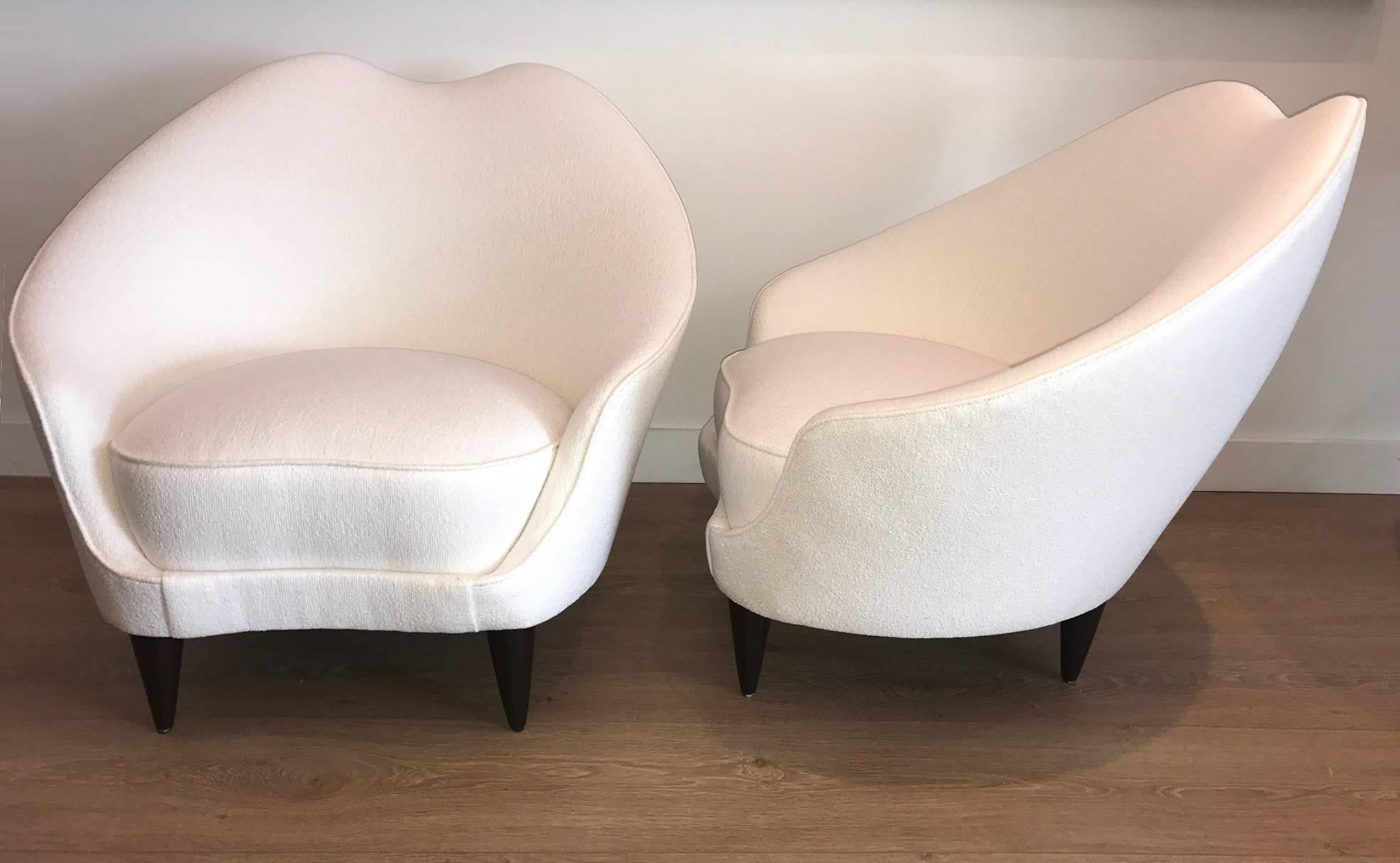 Curvaceous mid-century Italian lounge chairs by Federico Munari, Newly upholstered with a white bouclé fabric, dark stained conical wooden legs.
 
 