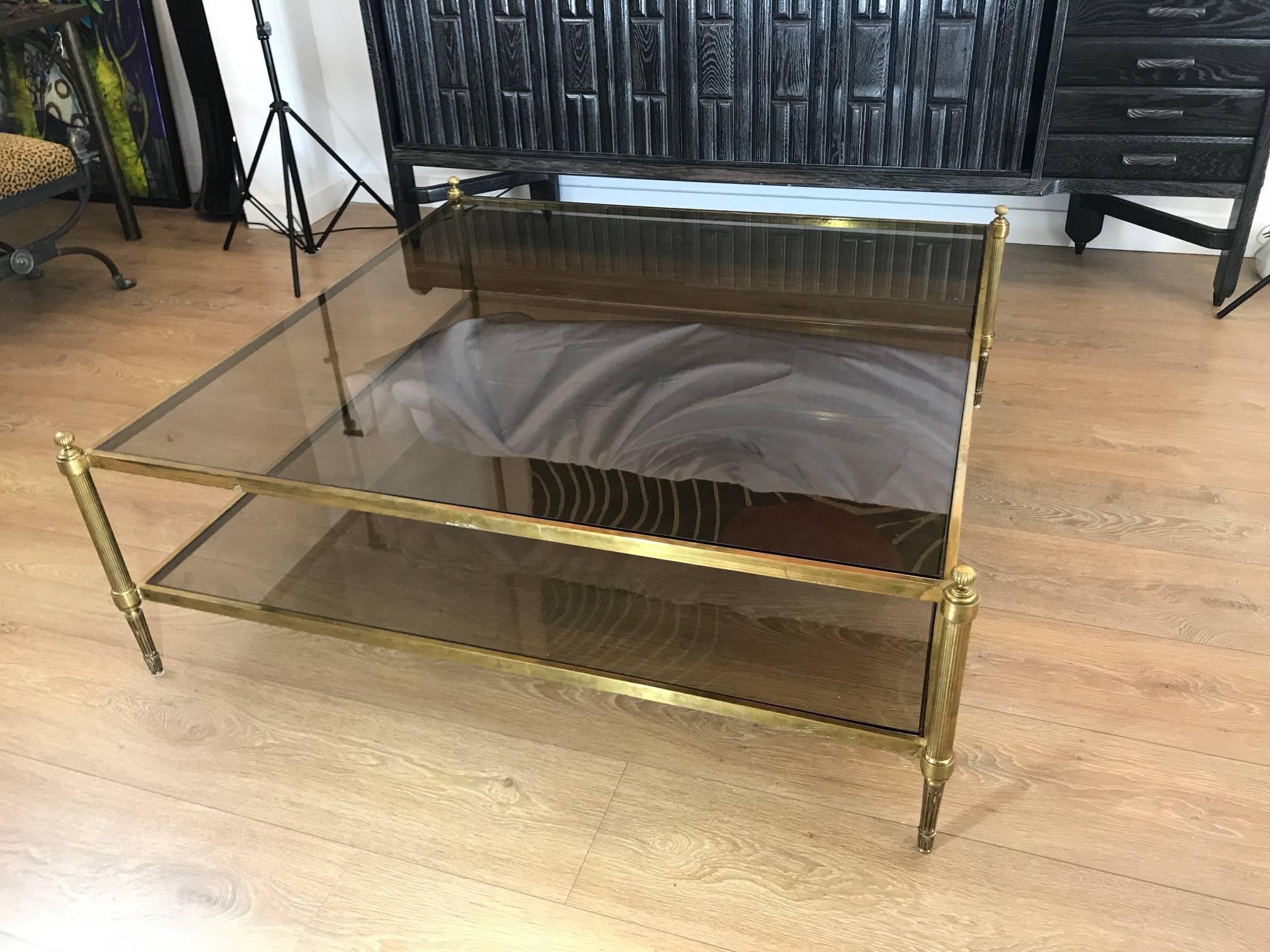 A superb over-sized two tiers brass with inset glass coffee table, France, circa 1950s, attributed to Maison Jansen