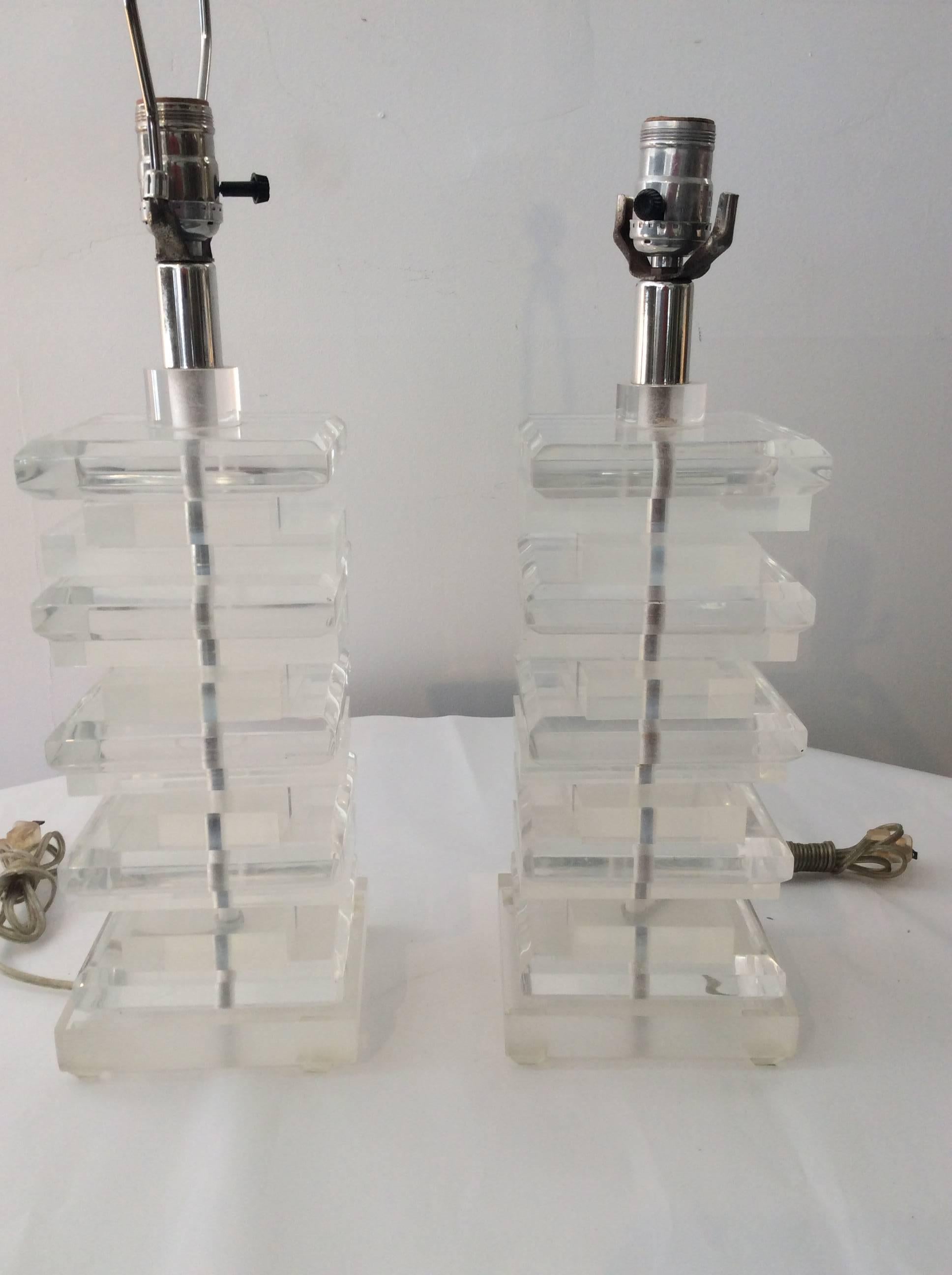 You are looking at a very versatile pair of Chuncky clear Lucite table lamps. These lamps would work in many decor styles. They are vintage and are in good overall condition with expected wear consistent with age. The Lucite is pretty much clear.
