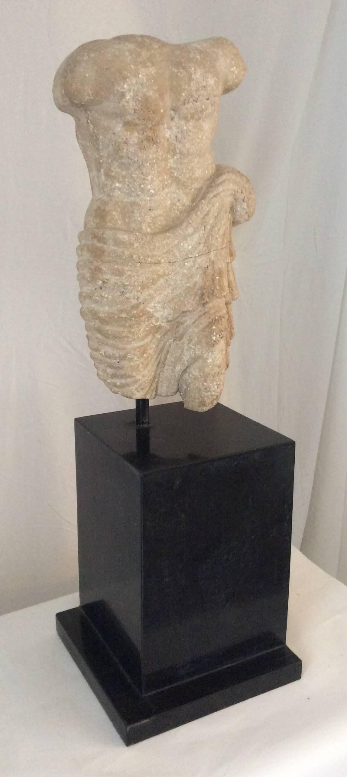 You are looking at a very decorative stone sculpture of a Greco / Roman male torso. Don't know exact age for I don't espcialize in this type of thing. I do know it's vintage. It appears to be made of some kind of stone. The sculpture rest on a