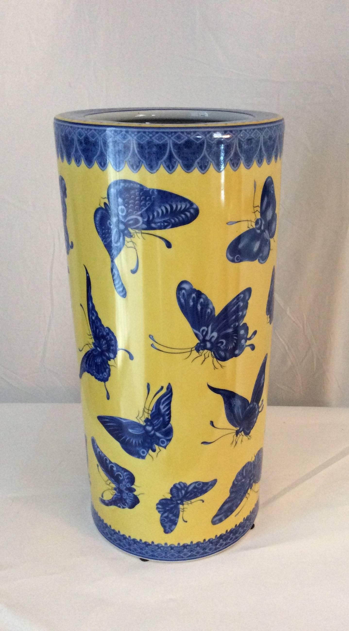 You are looking at a beautiful umbrella stand done in porcelain with a yellow background and stunning transferred butterflies in a cobalt blue color. There is also a accent border on the top and bottom in the same color. The contrast of the colors