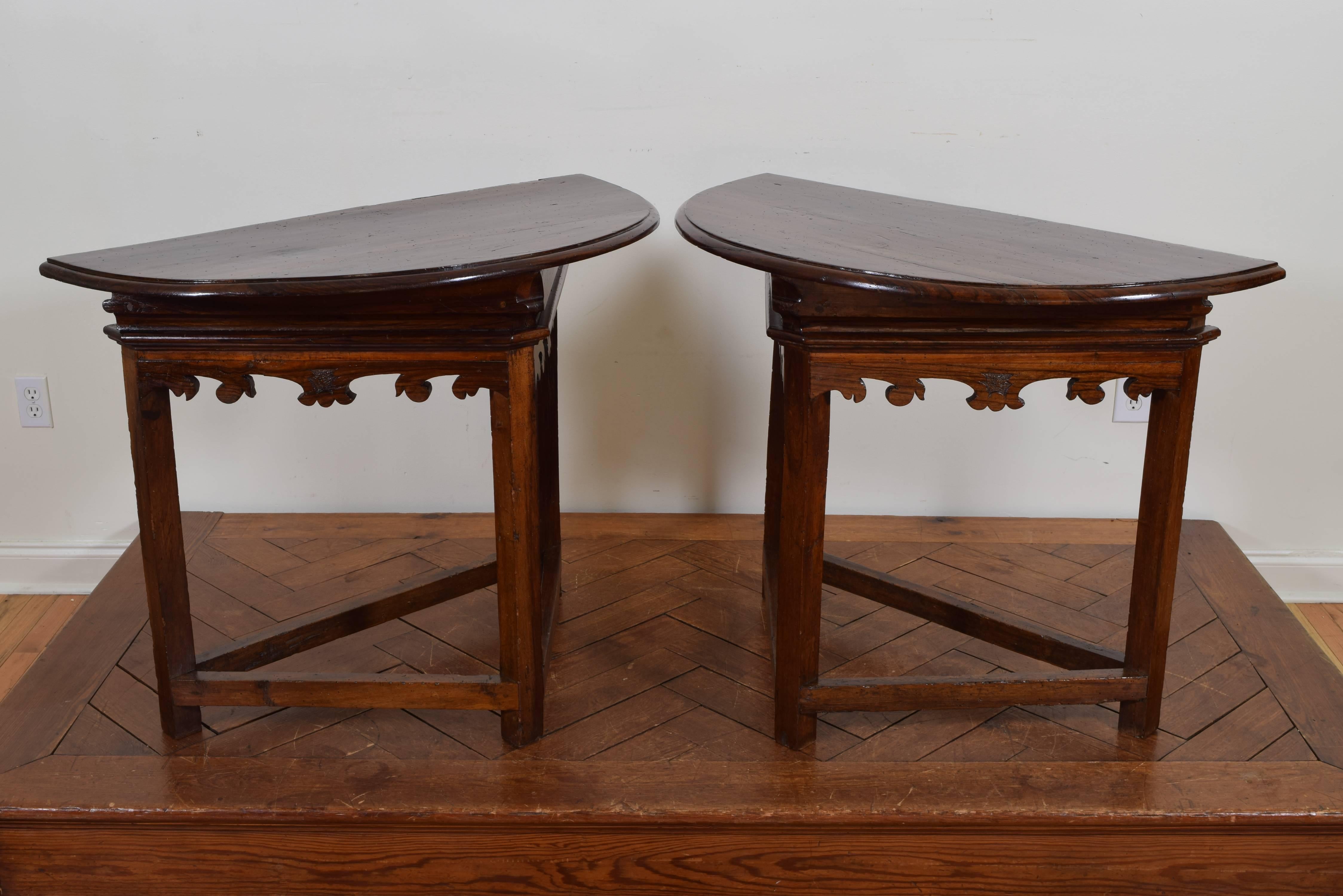 Constructed of rosewood and having half round tops above triangular frames with molded friezes and carved aprons, raised on straight legs joined by triangular stretchers.