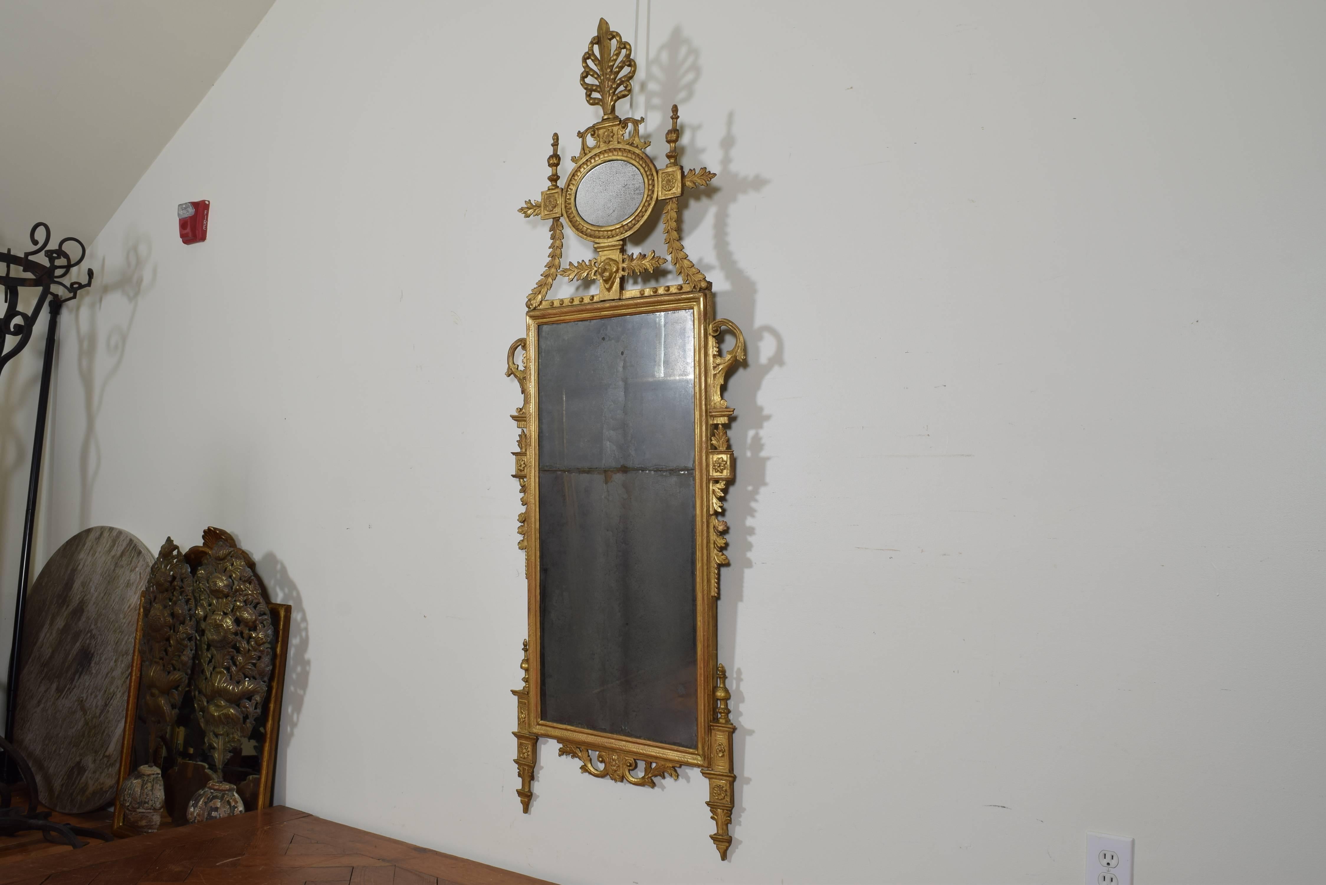 Exquisitely designed and carved, an excellent example of Tuscan workmanship showing the delicacy and workmanship typical of the period, the frame raised on tapering legs and flanked by foliate accents and rosettes, the top with bellflowers leading