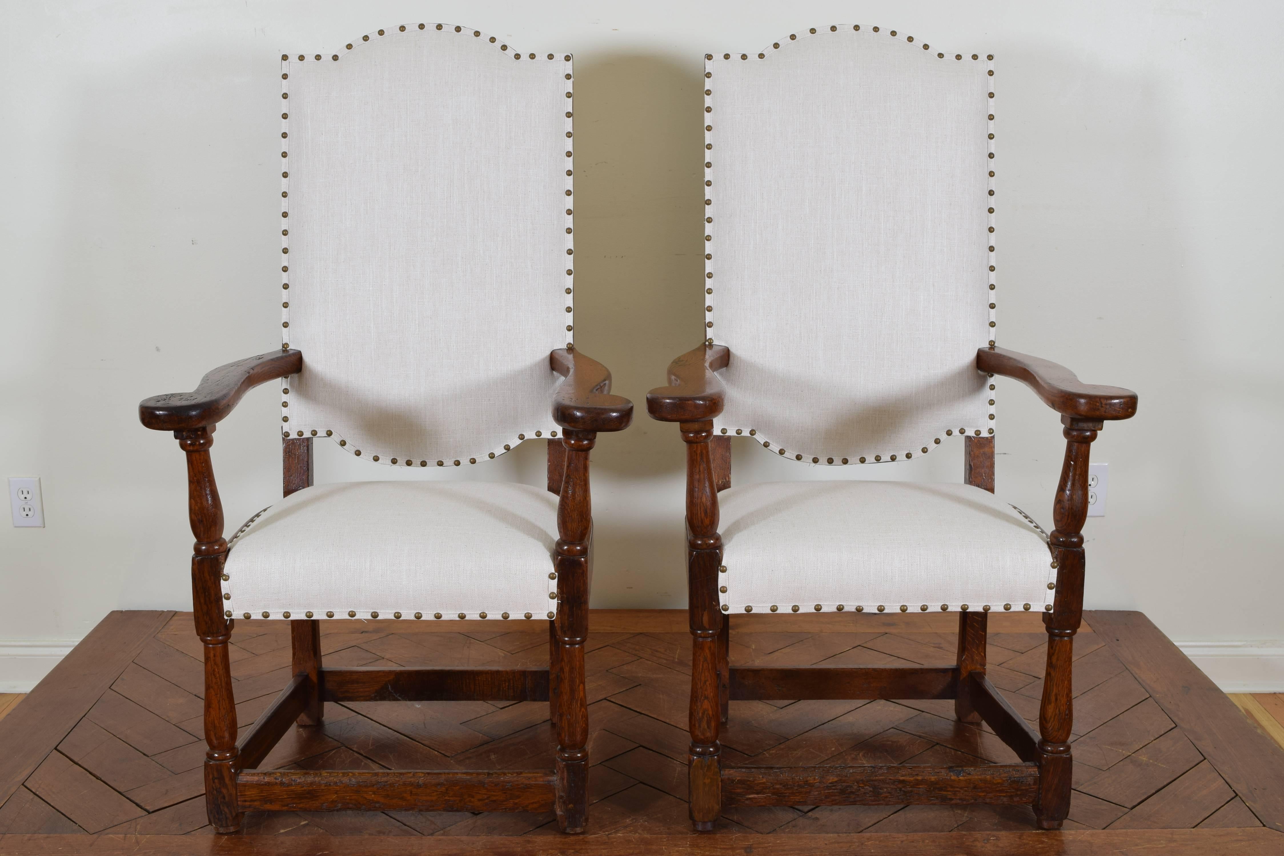 In the Renaissance style with wide arms and deep seats, having shaped backrests and outwardly turned arms in the style of a caquetoire chair, box stretchers.