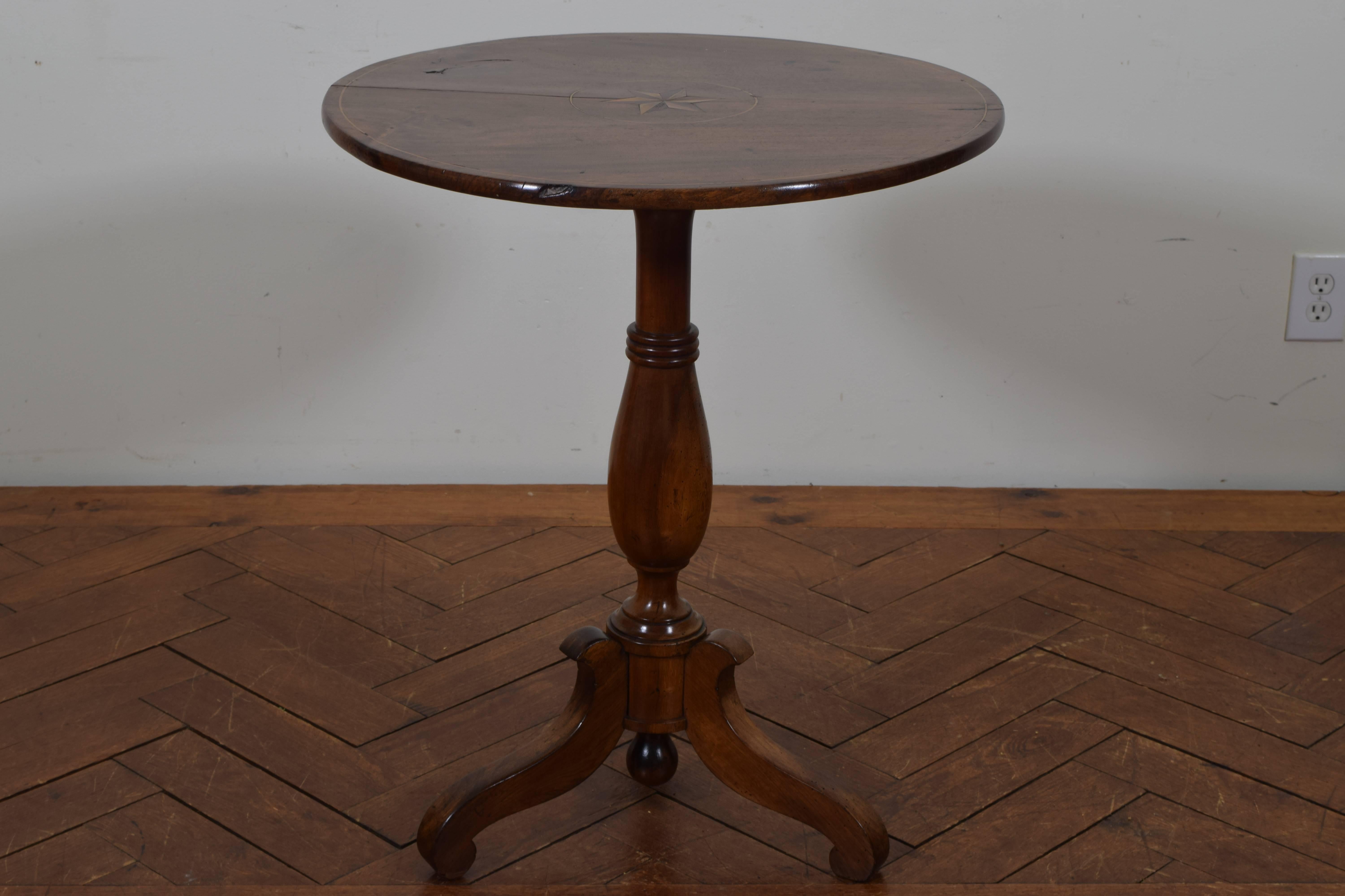 The circular top with an outer inlaid band and a centered star within a circular band, raised on a turned standard atop a round base issuing three curved legs with downward circular feet.