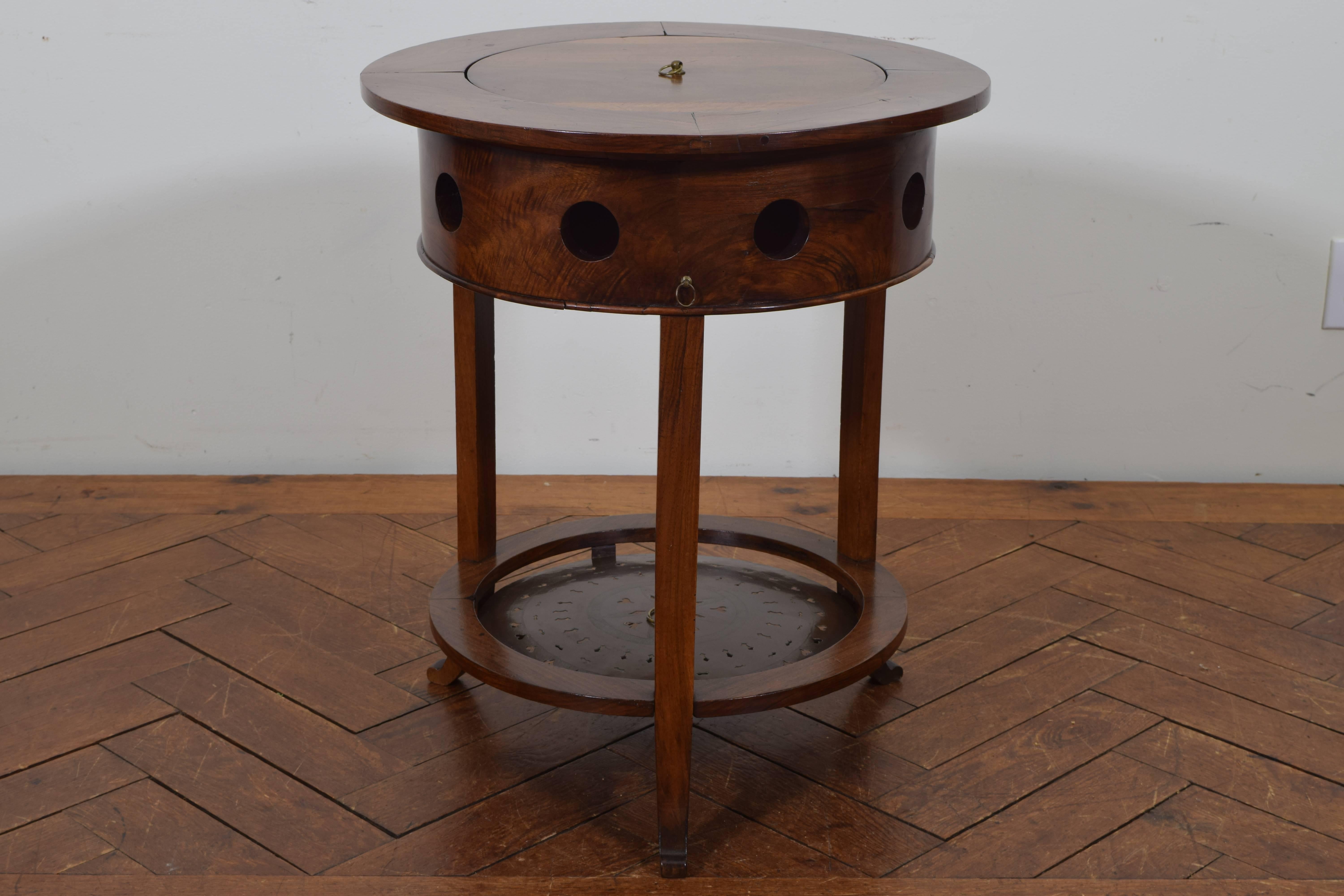 This very unique metamorphic table has a removable round top and an inner metal framework at the upper and lower sections that holds a brazier which was used to hold coals for warmth, the side vents allowing the heat to escape the table. It can be