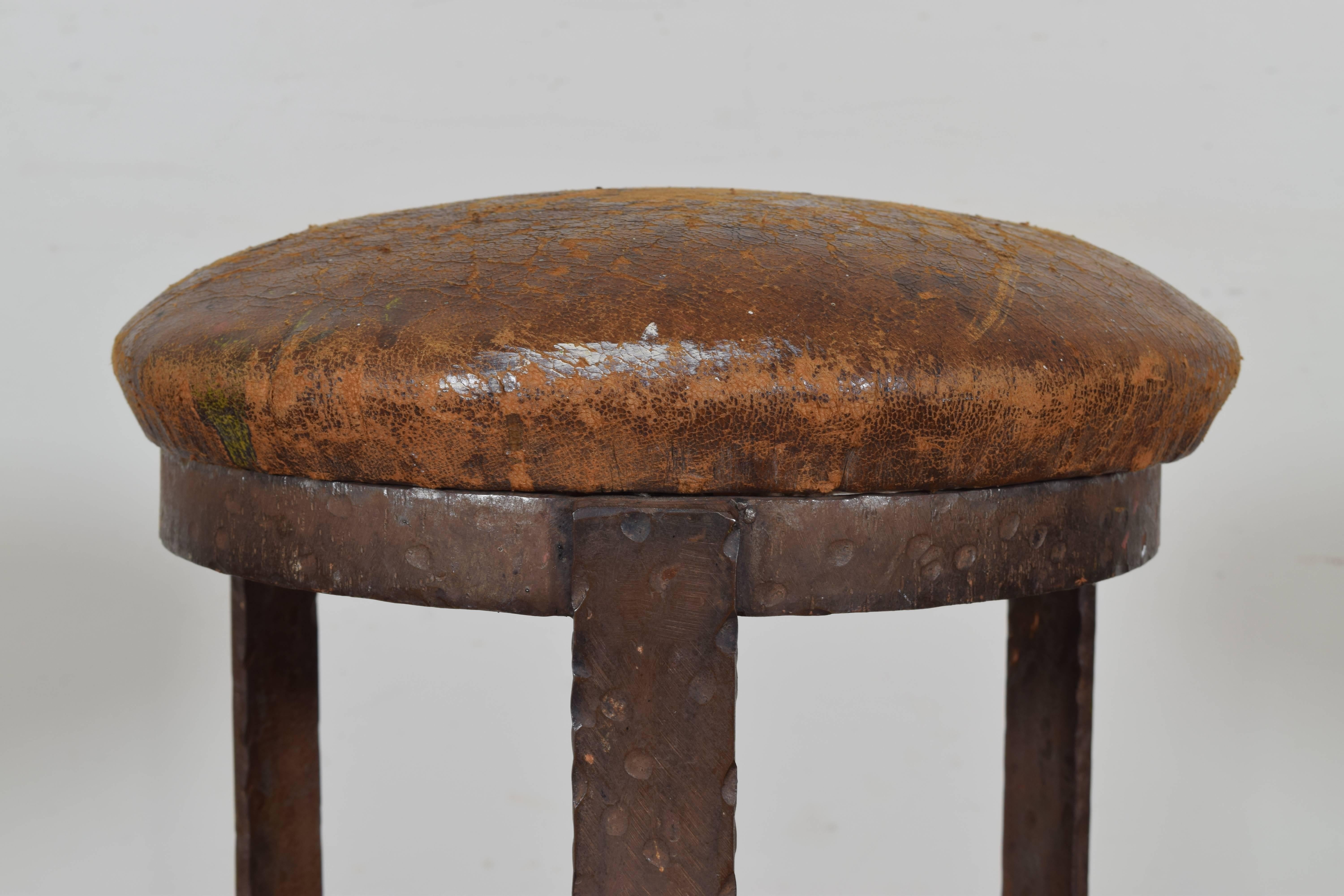 Three legs with round stretchers, with a drop in leather upholstered seat.