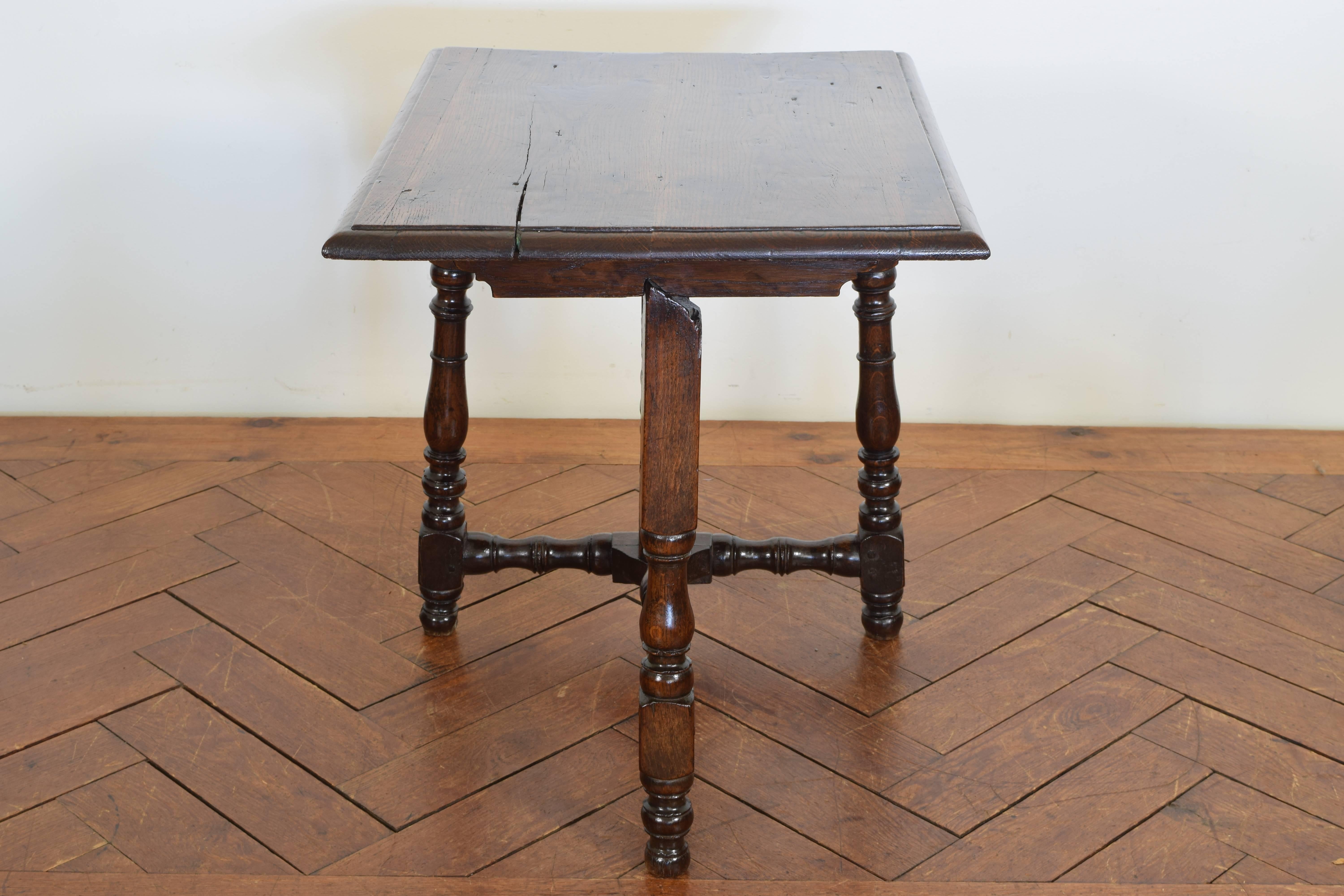 The rectangular top with a molded edge, hinged atop a framework of turned legs and stretchers.