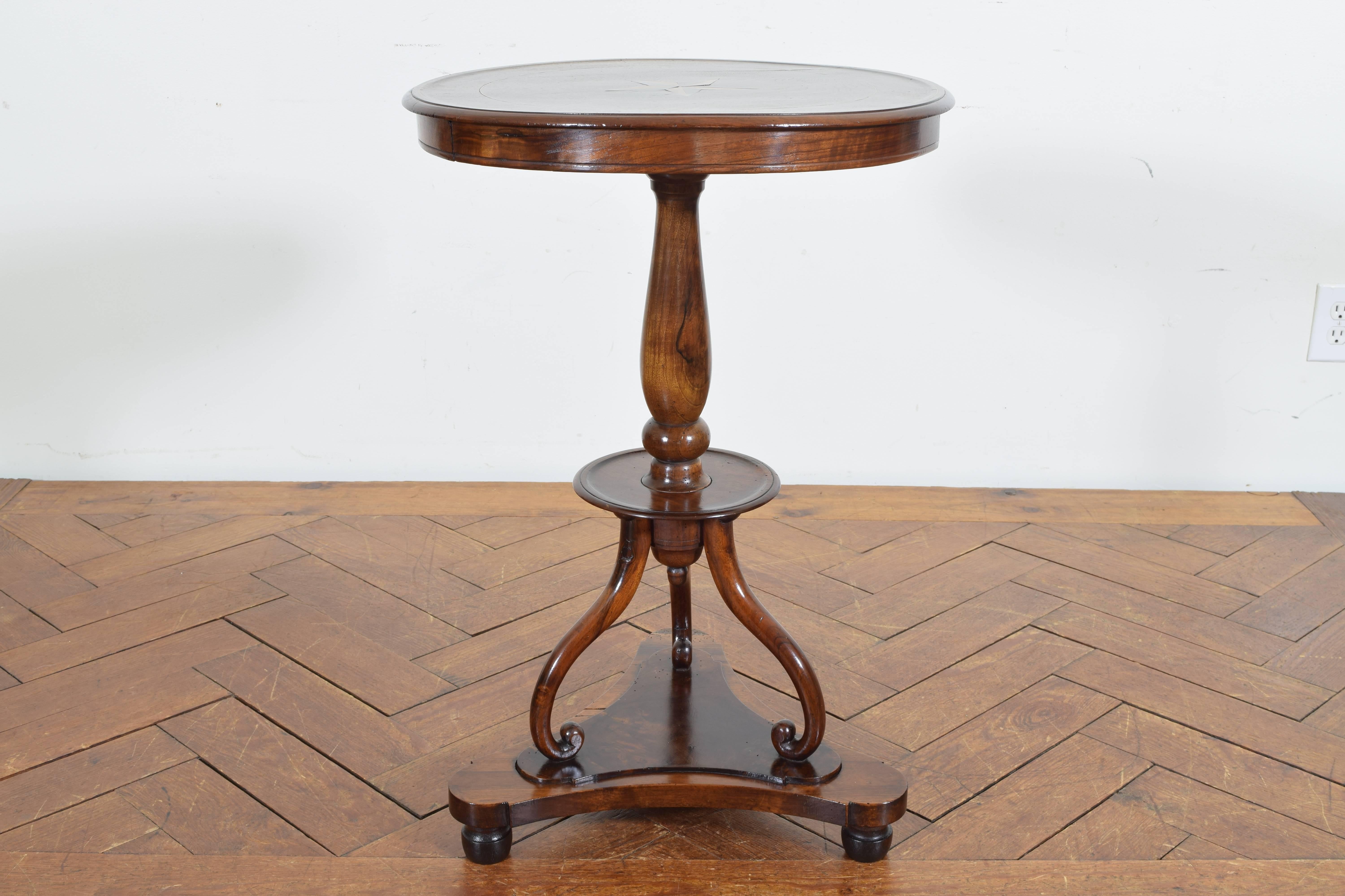 Having a round top with a central star inlay, band inlay, and a molded edge, the top housing two small drawers, raised on a turned standard with a lower tray section, the curved supports above a tripartite base raised on ball feet
2nd quarter 19th