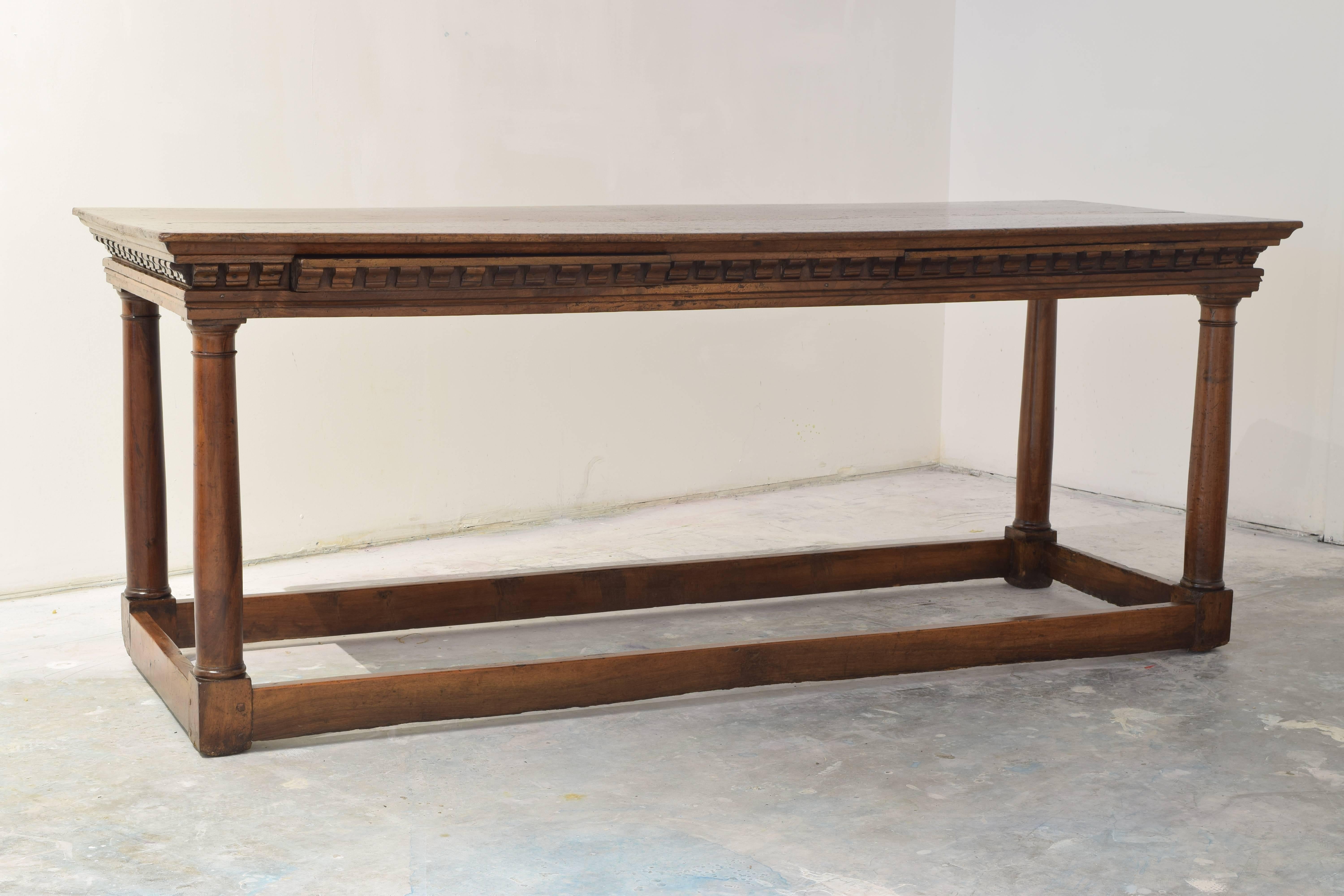 Two hidden drawers carved within the dentile molding apron and full box stretcher connected by four turned column legs.