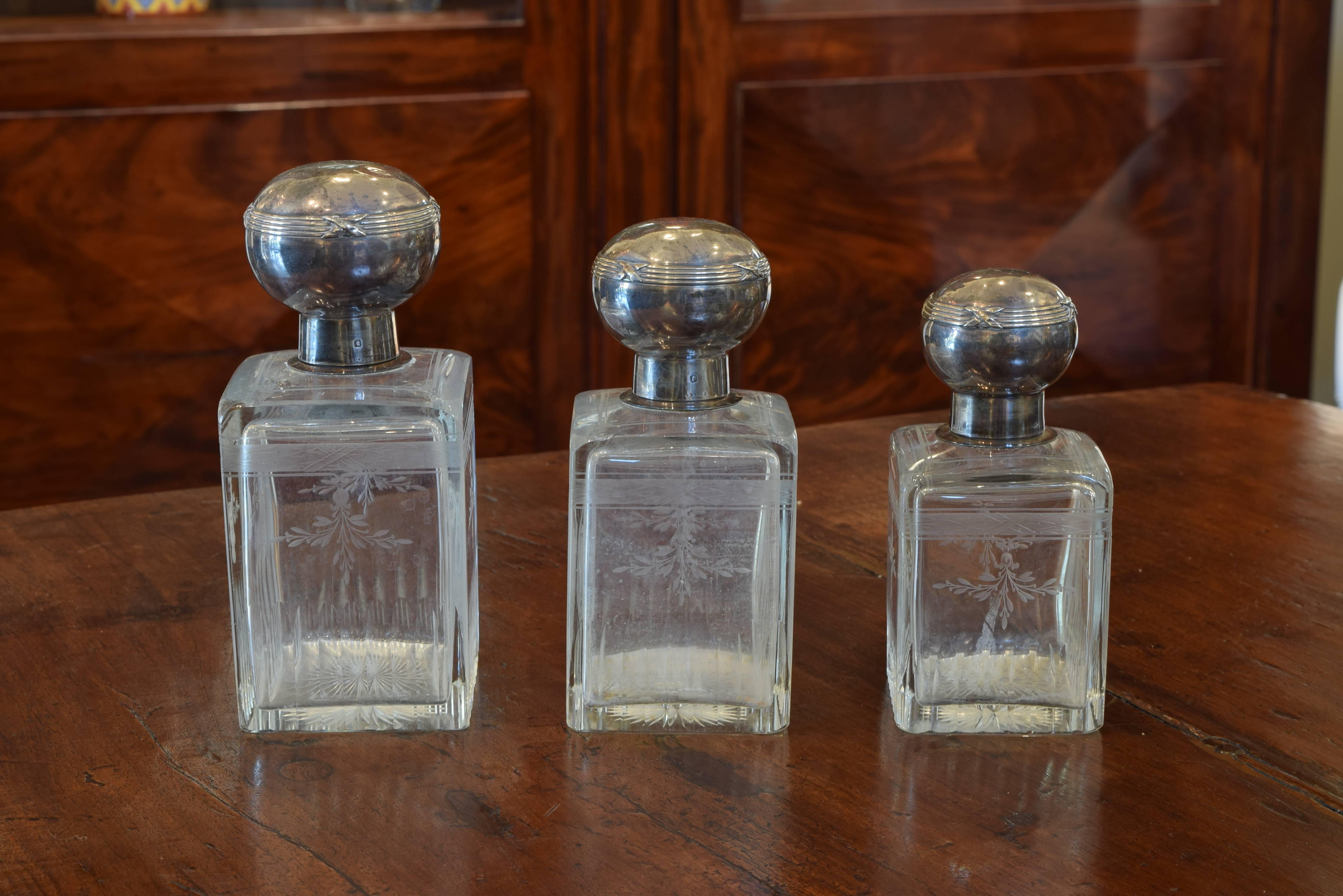 The three with matching decorations and of graduated size, the sterling silver tops with decorative banding, likely part of a larger vanity set, measurement is of the tallest of the set.