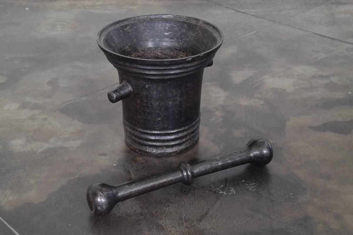From the Louis XIII period and forged or steel, the mortar with a flared top, ring decorations, and pouring handles, together with its original pestle (11 inches).