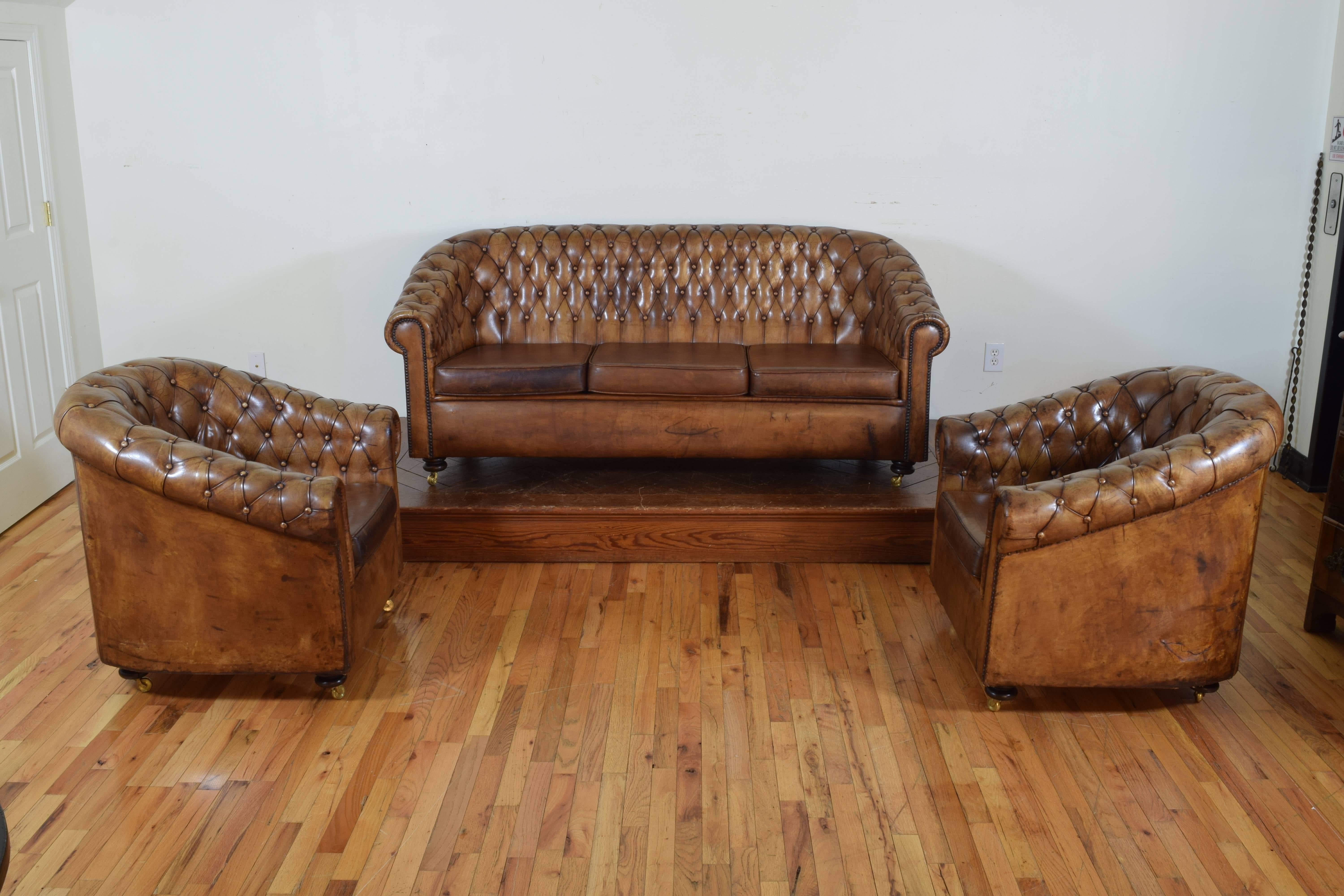 The set consisting of a three cushion sofa and a pair of bergeres, all having loose foam filled cushions, with wooden compressed double bun feet and brass casters, the condition very good with some old repairs (please see photos), measurement listed