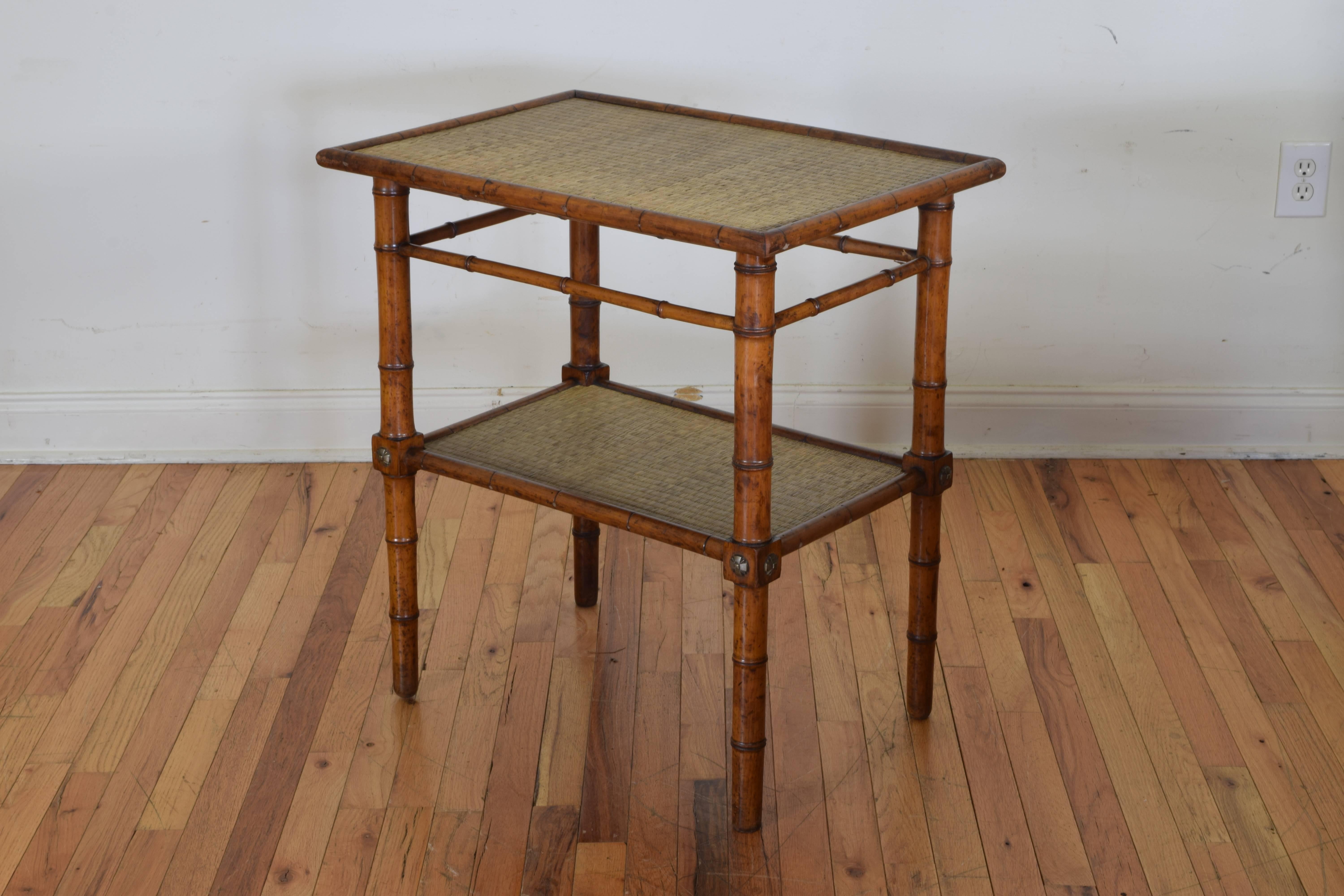 Having two rectangular tiers with rounded bamboo edges and covered in seagrass, with patinated brass Art Deco ornamentation.