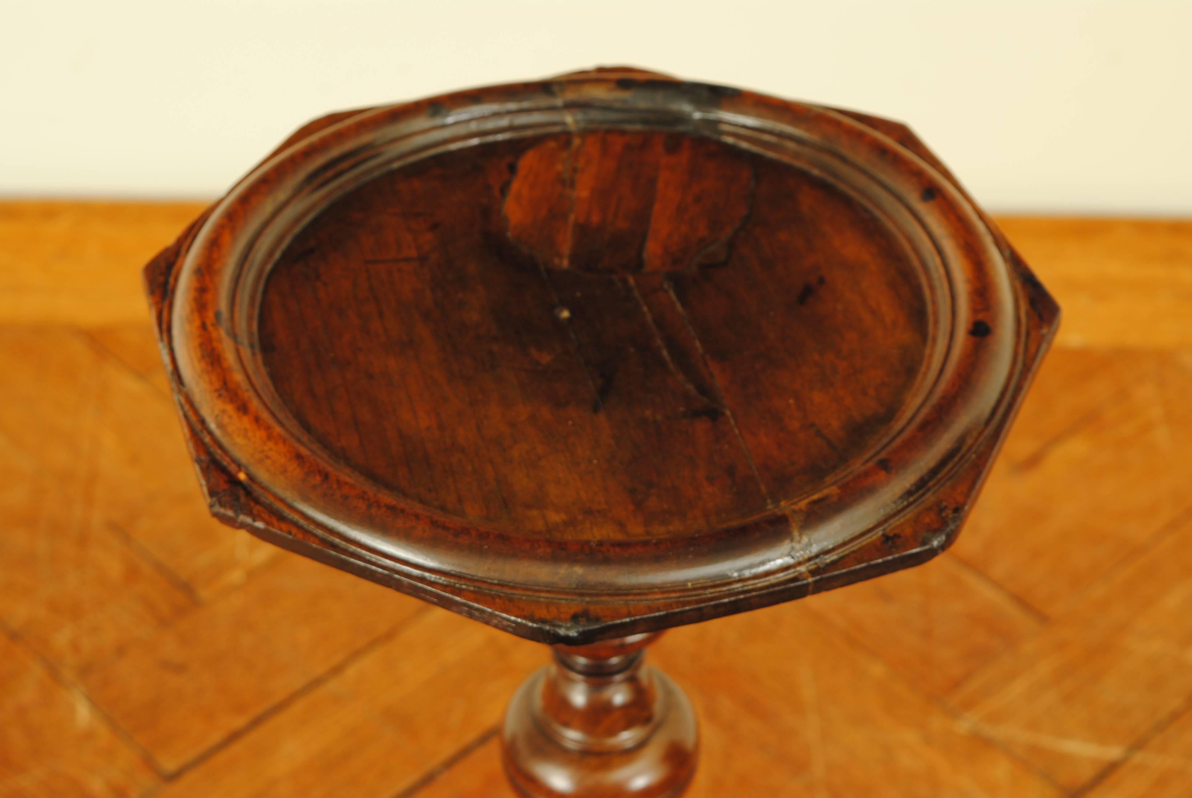 the molded edge octagonal top atop a turned support resting atop a round base  and resting on small bracket feet