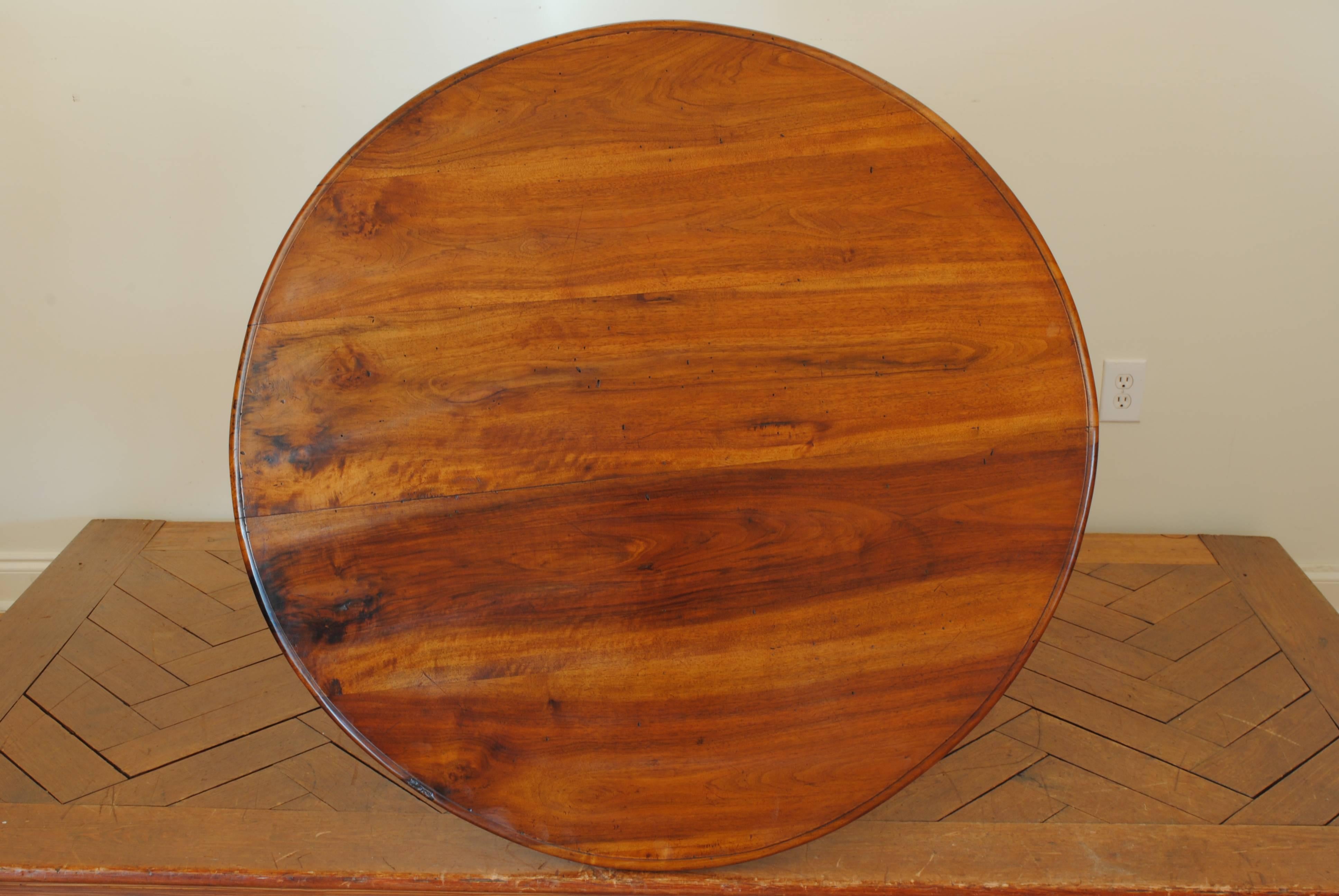 The circular top having a molded edge, once a tilt-top and now stationary, raised on a turned columnar standard on a tripartite base with curved legs, the feet with height added, second quarter of the 19th century.