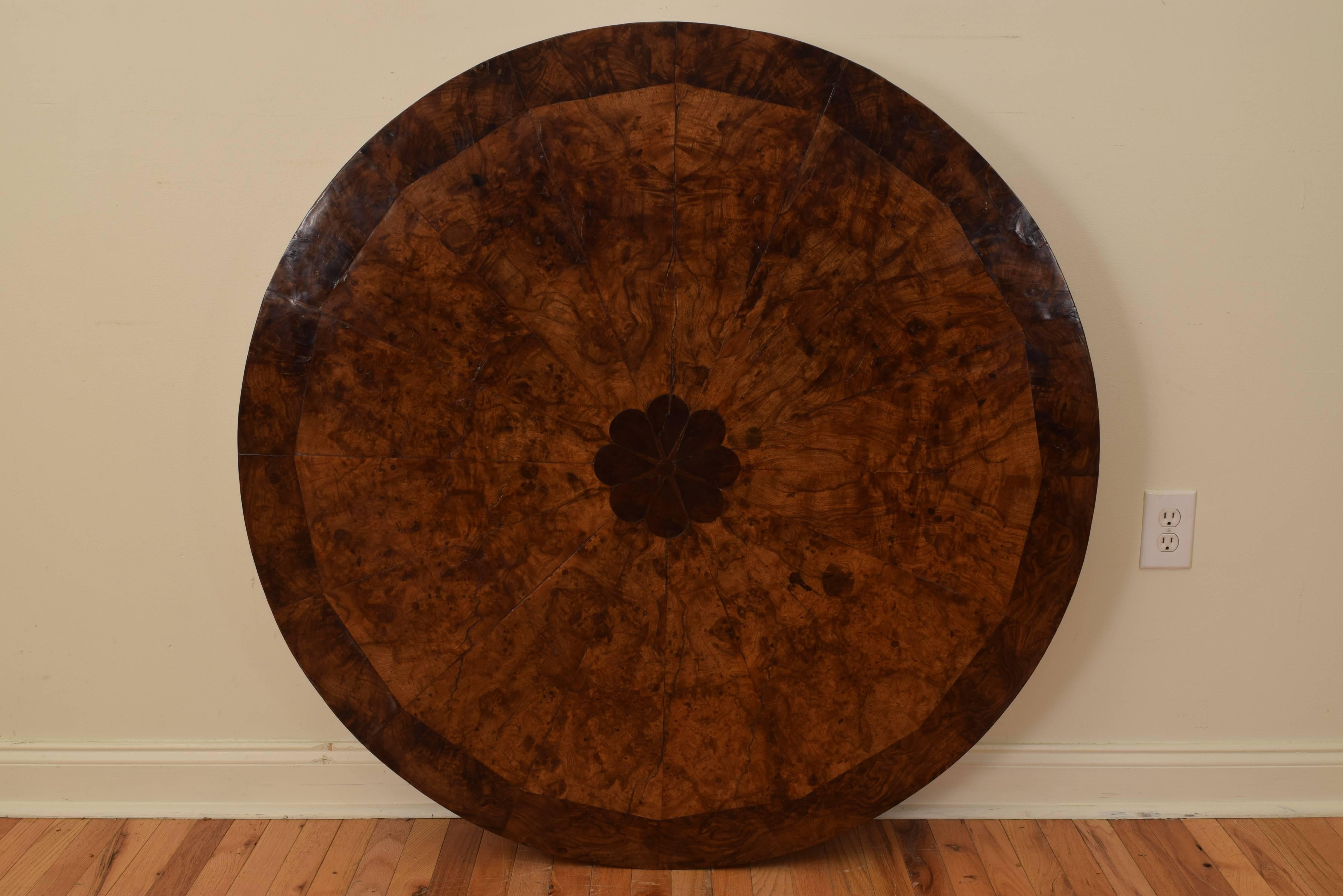 Likely from Rome in the Lazio region of Italy, having a circular top covered in walnut veneer in triangular wedges radiating from a centered darker fruitwood floral medallion, a veneer of similar color completing the outer edge of the top, the outer