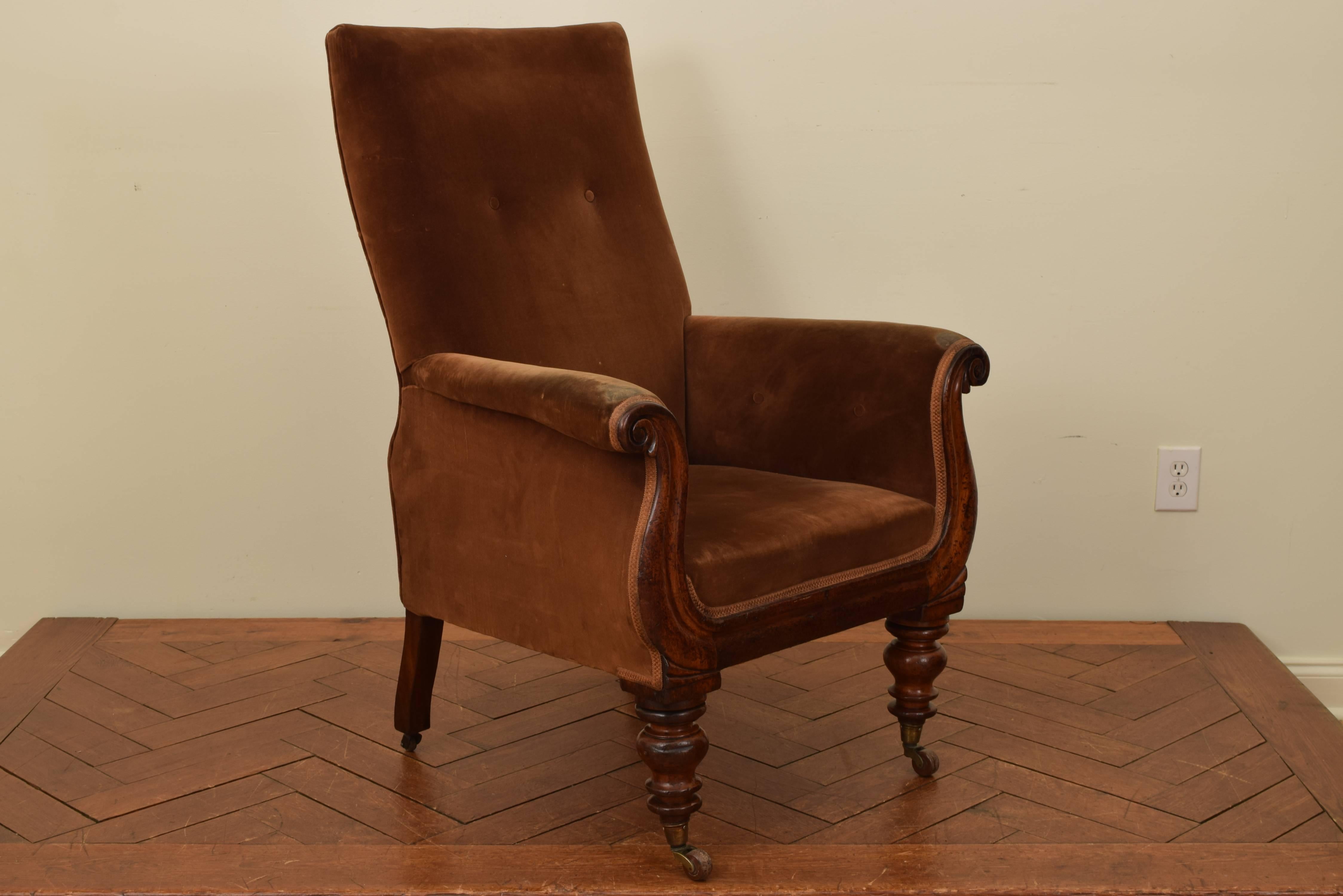 William IV walnut upholstered armchair having a slightly leaning back with button tufting, the rolled arms are closed and also have button tufting, the front of the chair is shaped and carved in a lyre shape, raised on turned front legs and splayed