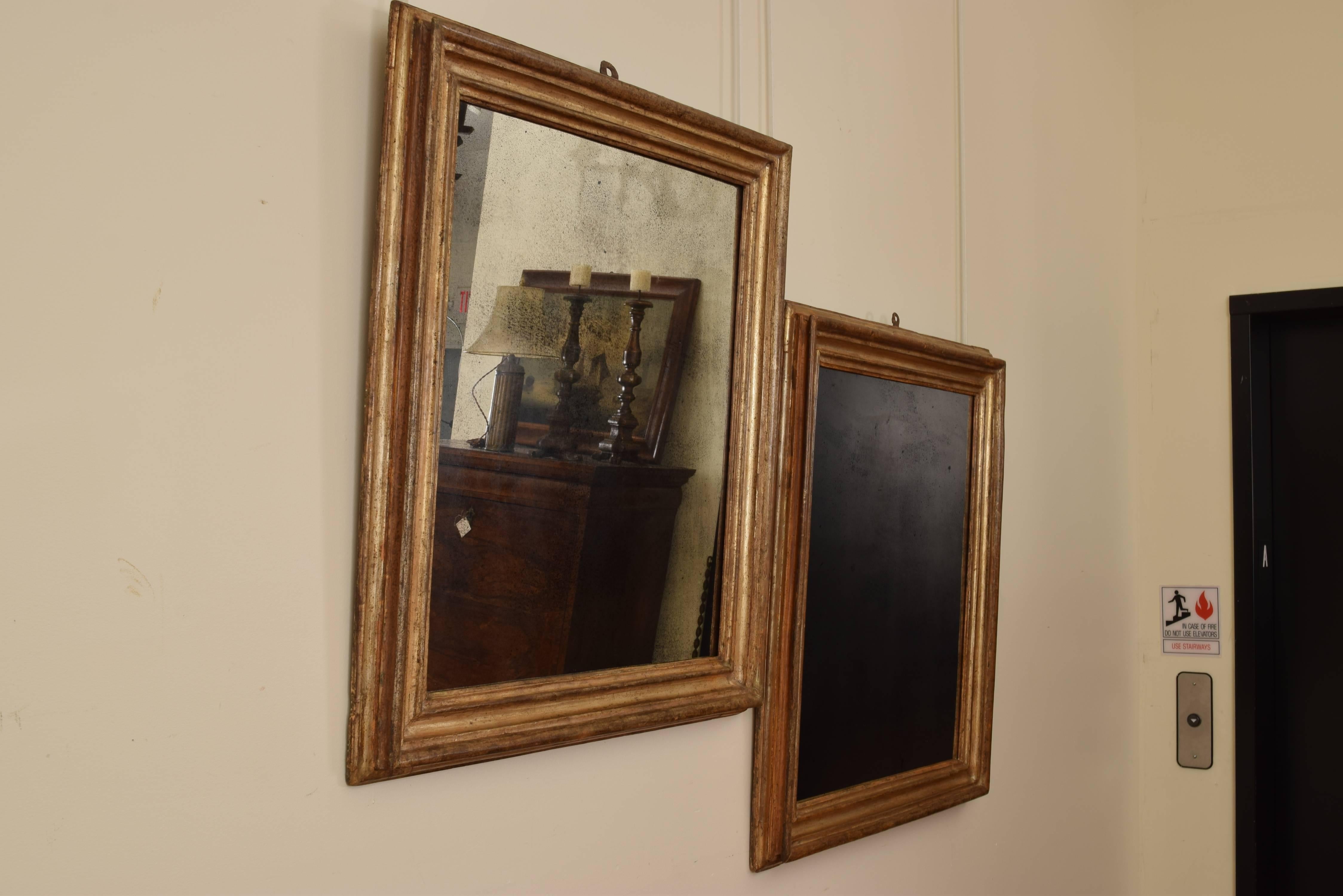 Pair of Italian late baroque silvered giltwood frames as mirrors the rectangular frames with multiple molded surfaces is covered in lacquered silver gilt also known in Italian as 