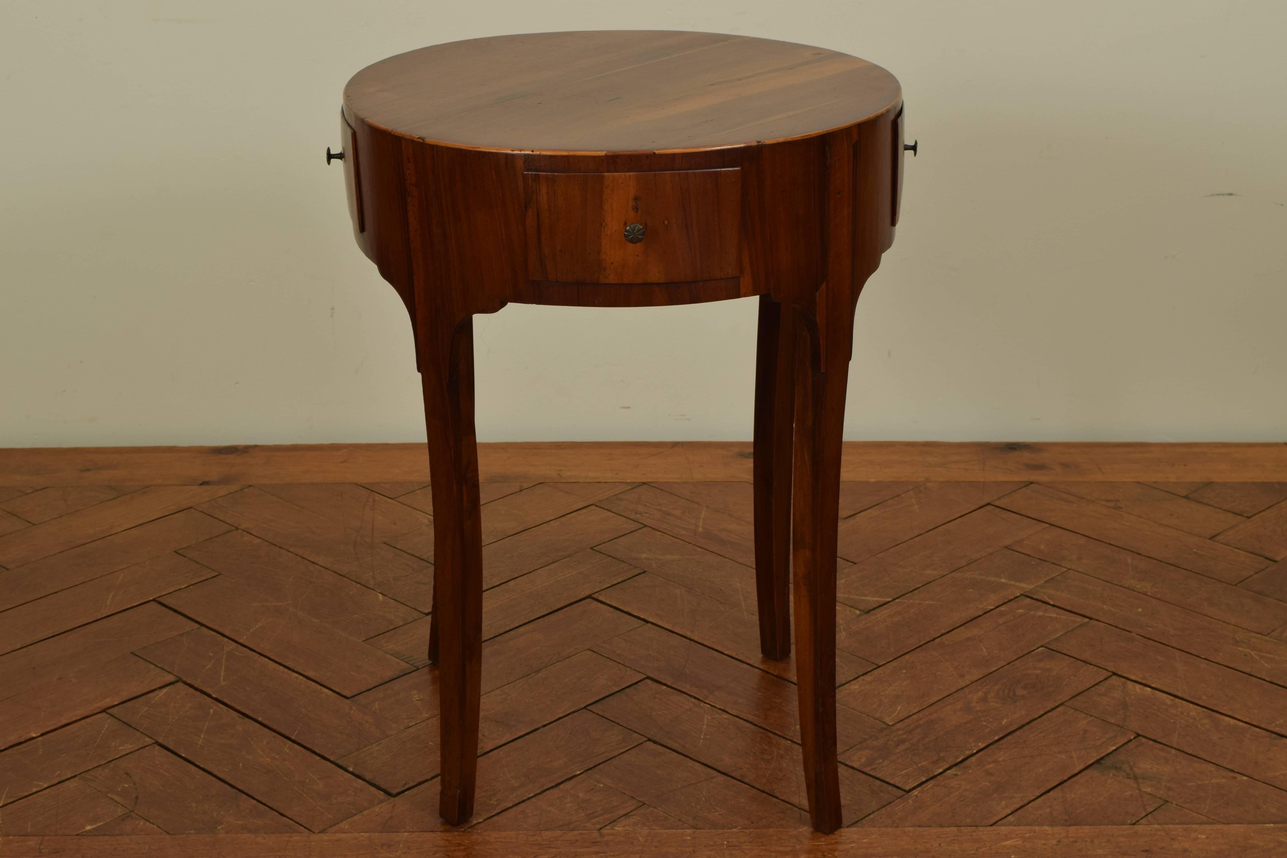 The round top above a conforming case housing four drawers, raised on slightly curved legs, second quarter of the 19th century.