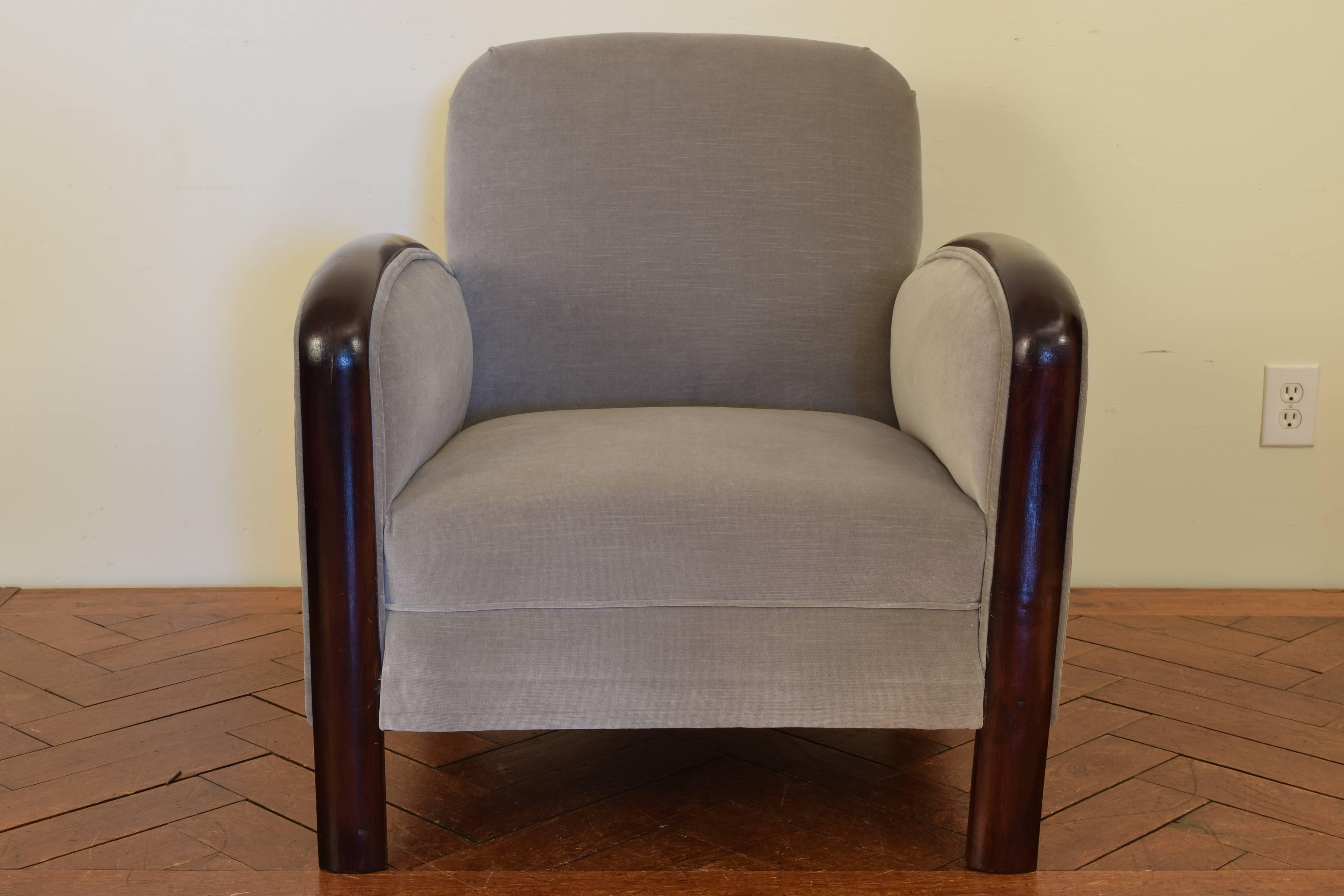 Having a sloped backrest and high flaring sides, the tight cushion raised on rounded legs.