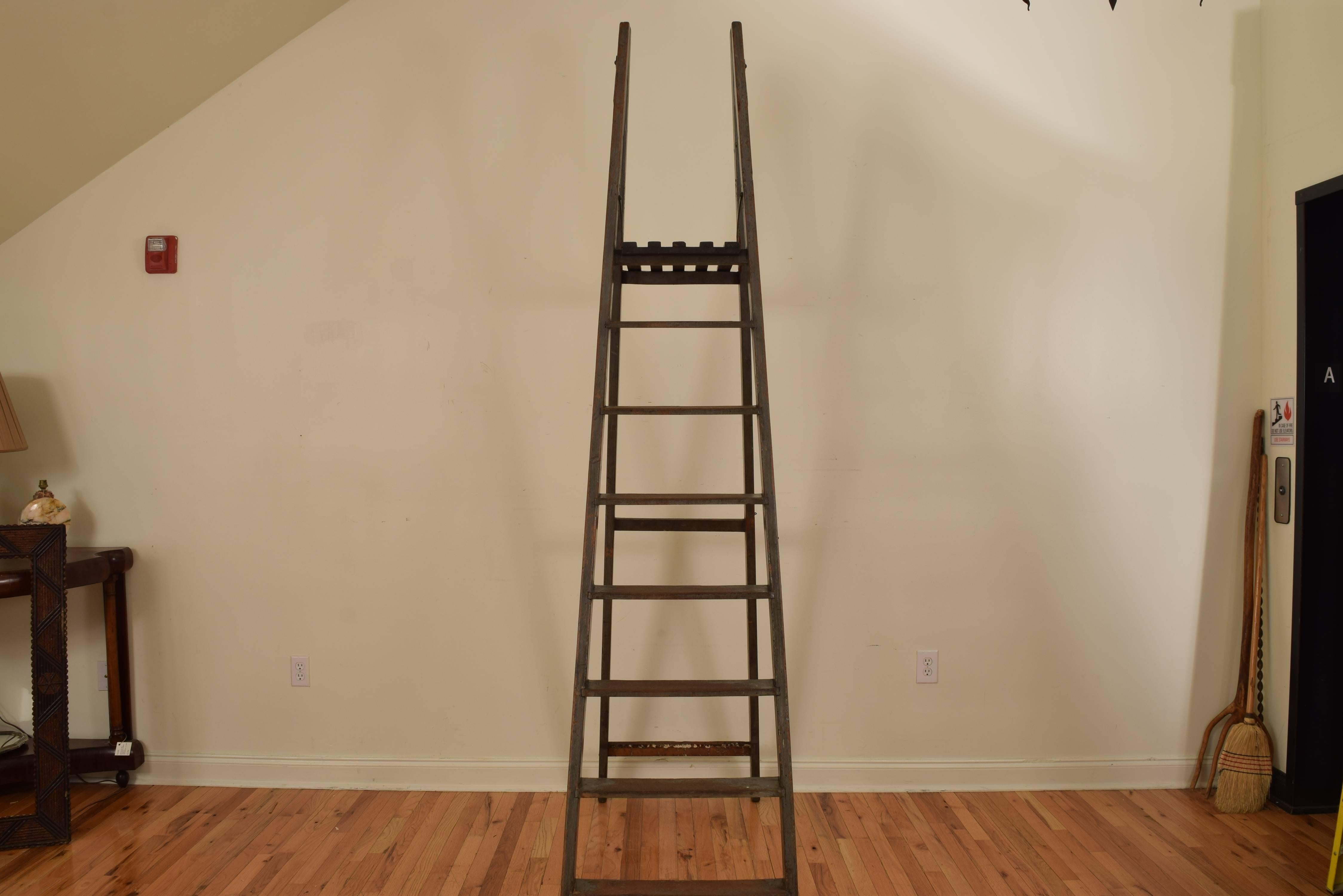 Folding ladder having seven steps and a slatted tray, retaining antique iron hinges and hook for storage, very stabile and usable condition, late 19th-early 20th century.