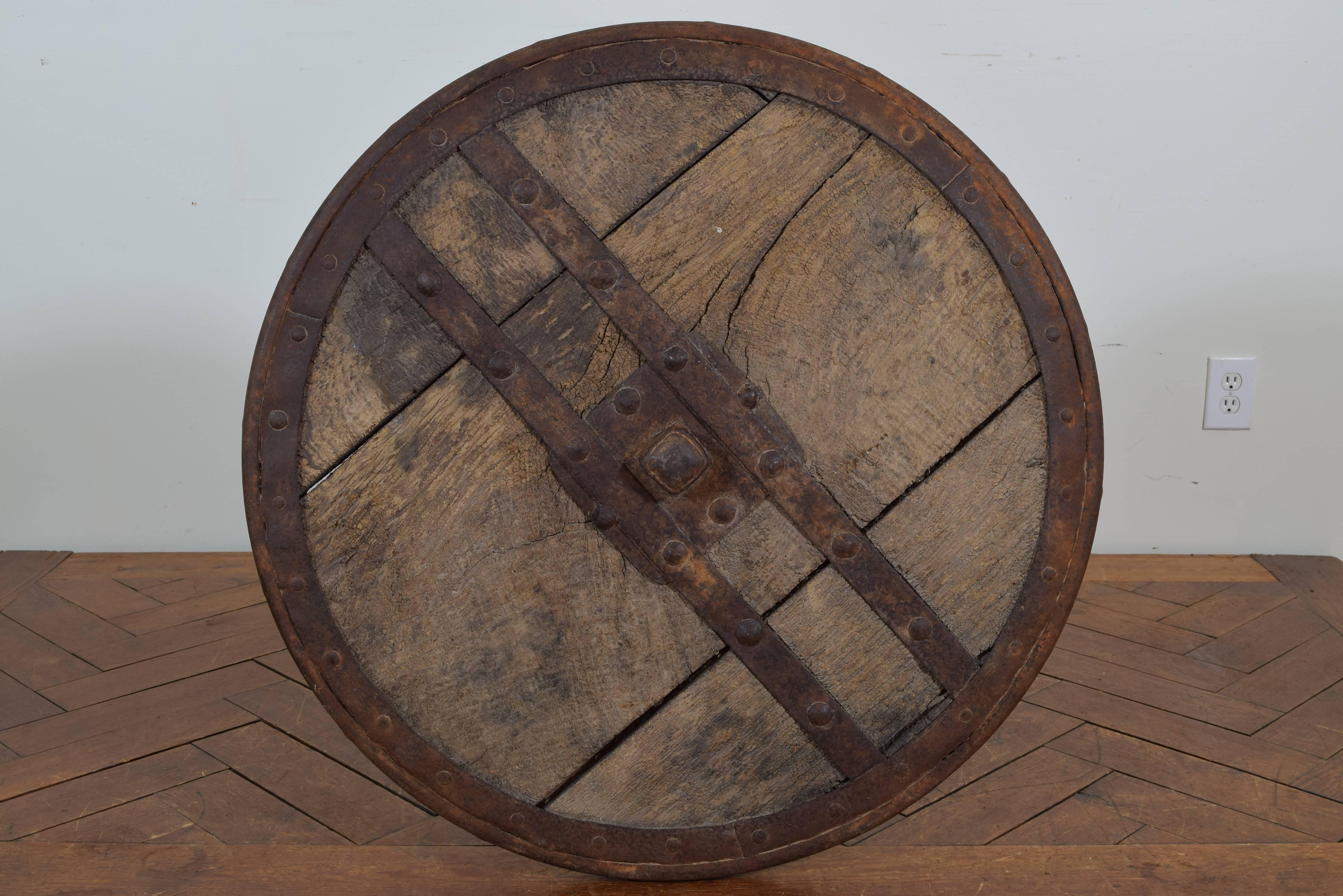 The wooden top with an iron band and iron braces bisecting it, raised section in center of top is 2