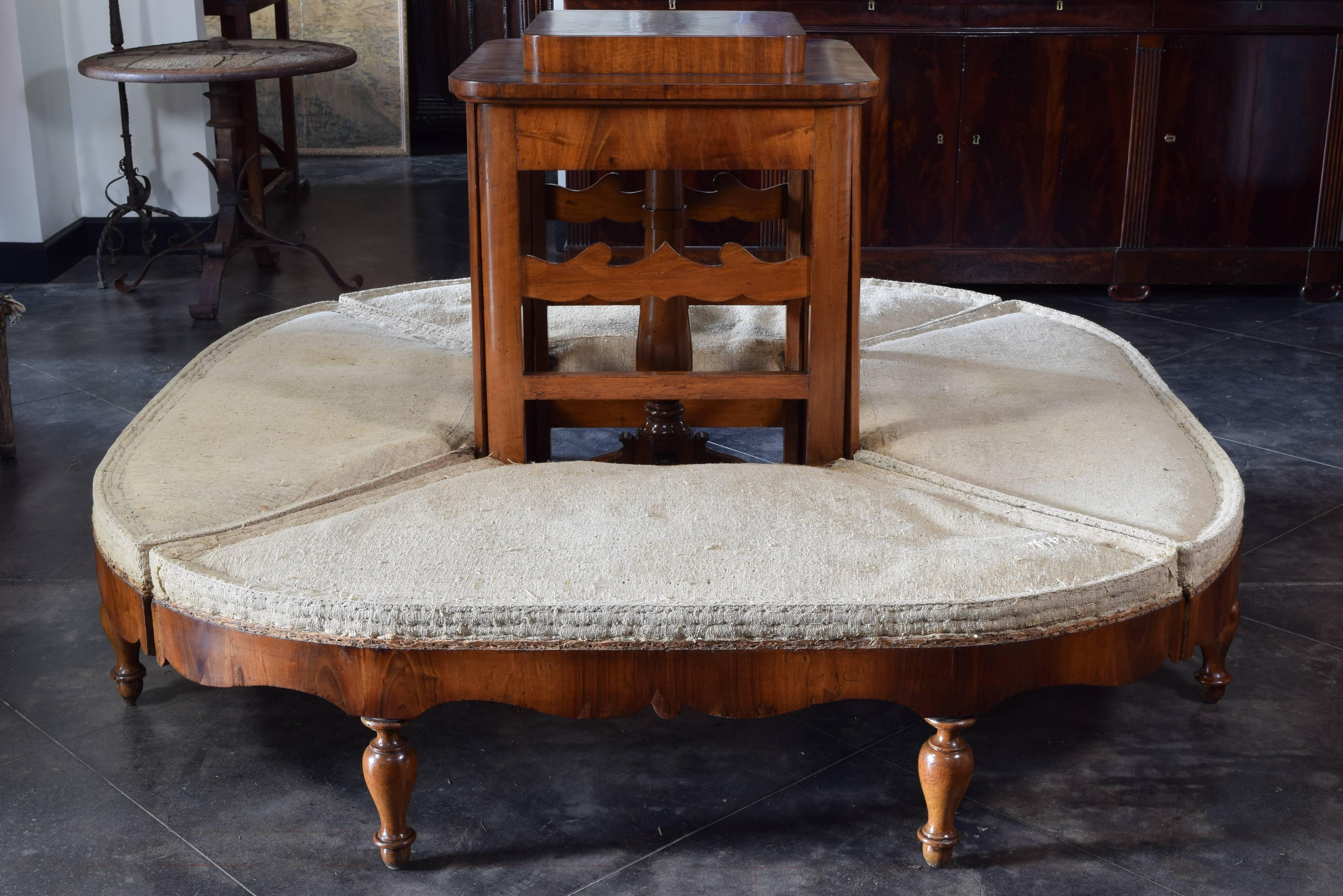 Wonderully constructed with a central four-leg table and a top enclosing the four seating sections, four-section Borne each section with a shaped ladder back, upholstered seat and raised on turned front legs, the sections hooking together securely,