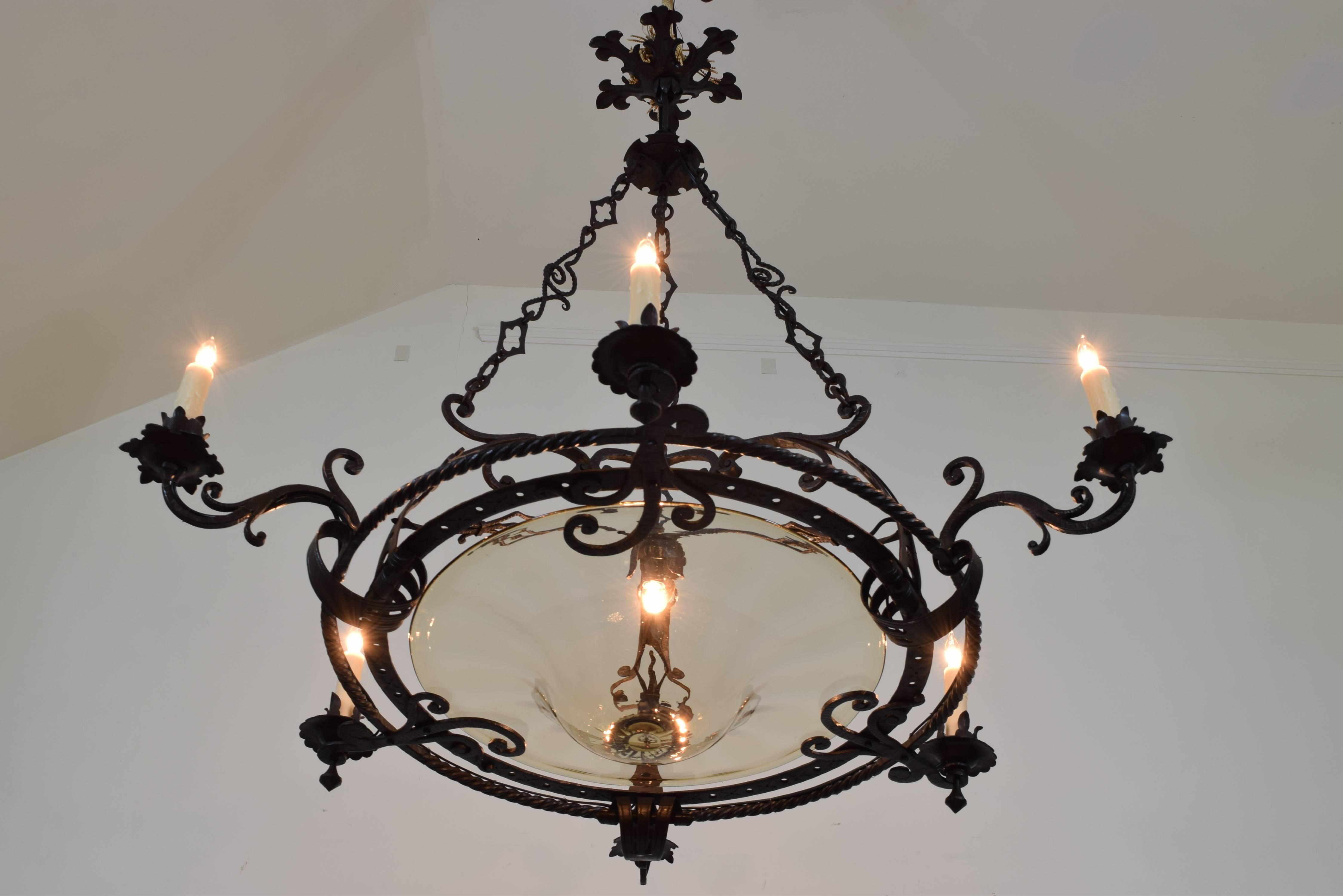 Wonderful example of the finely wrought iron chandeliers being made in and around Milan in the first quarter of the 20th century the detailed chain work hanging from a shaped canopy below an additional upper canopy, the circular body having scrolled
