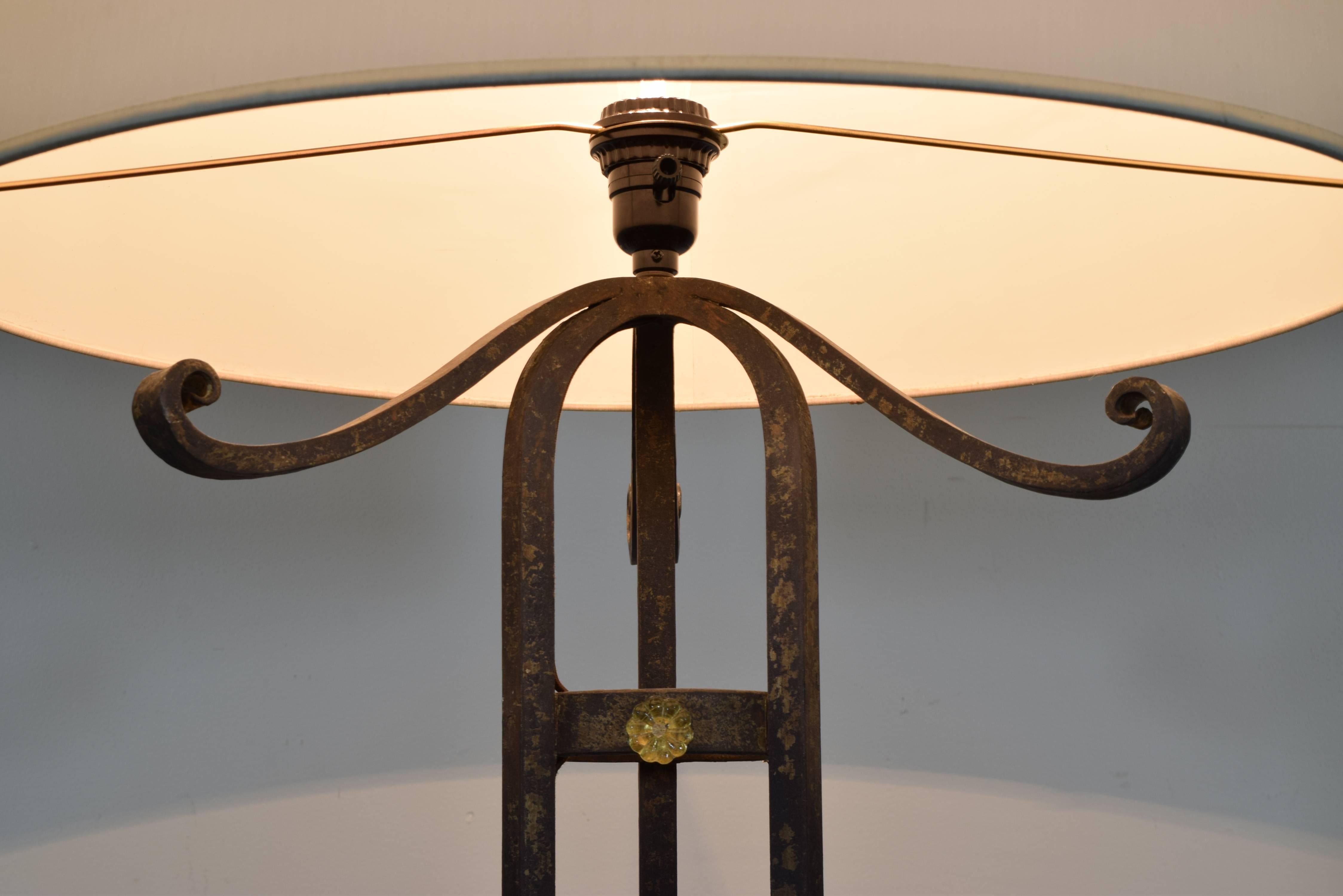 Art Deco wrought iron and glass floor lamp of cylindrical form and having a scrolled base, the standard decorate with glass rosettes, in perfect condition, second quarter of the 20th century.