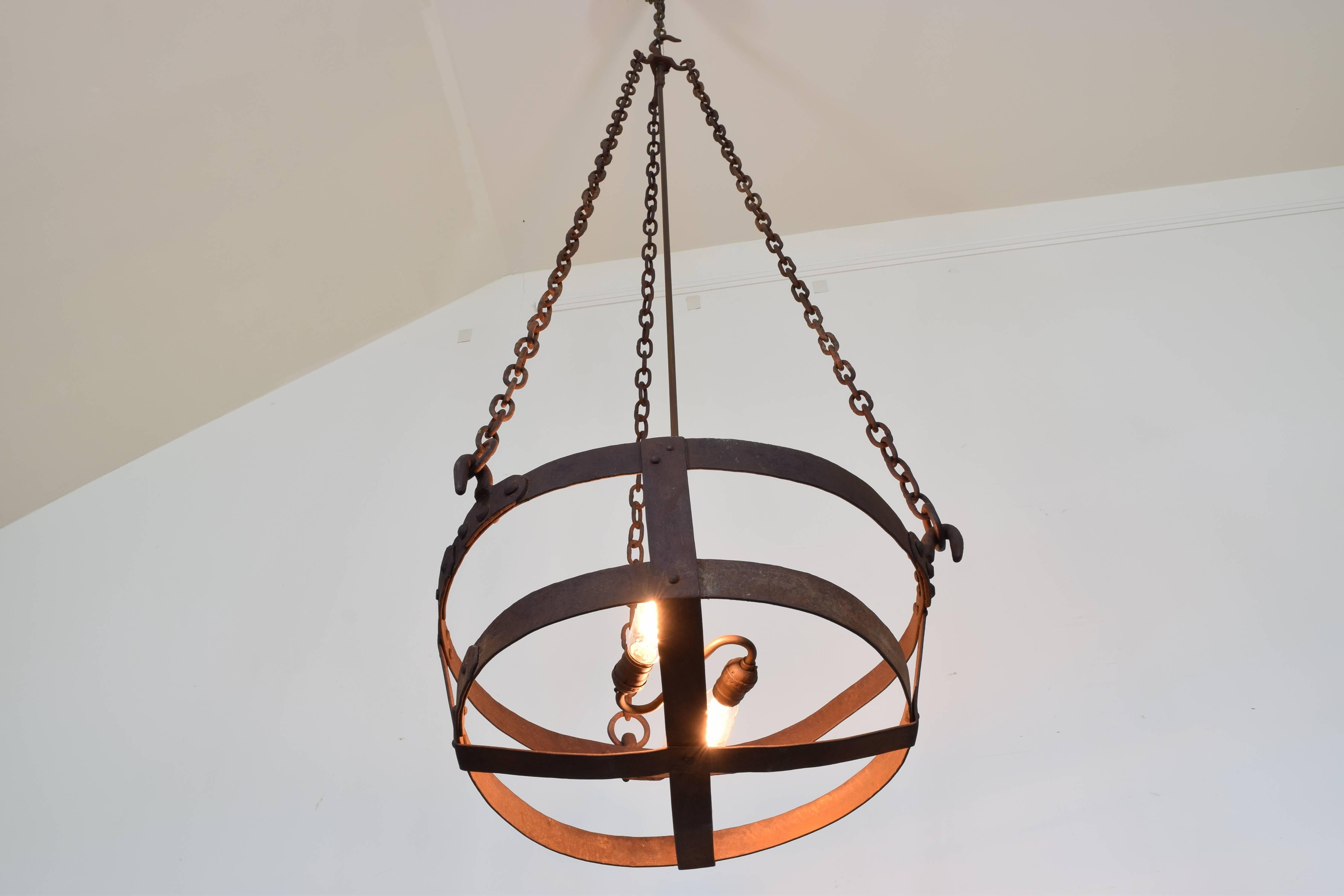 Hanging from three long chains, the open basket now illuminated with a two-light socket.