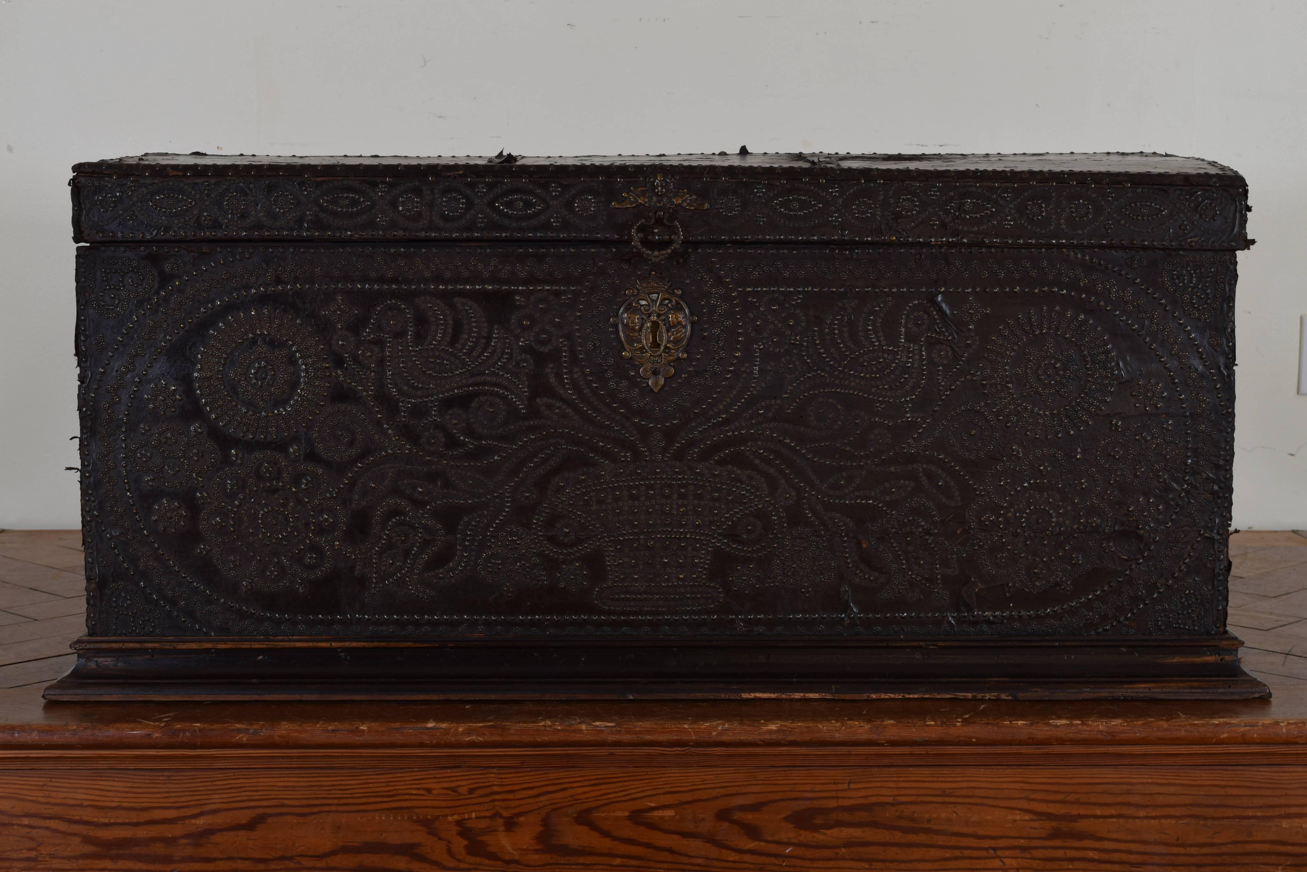 Of very shallow proportion and having been used at the rear of a coach, raised on a molded walnut Stand, having iron carrying handles and decorated with brass decorations and nailheads, 17th century.