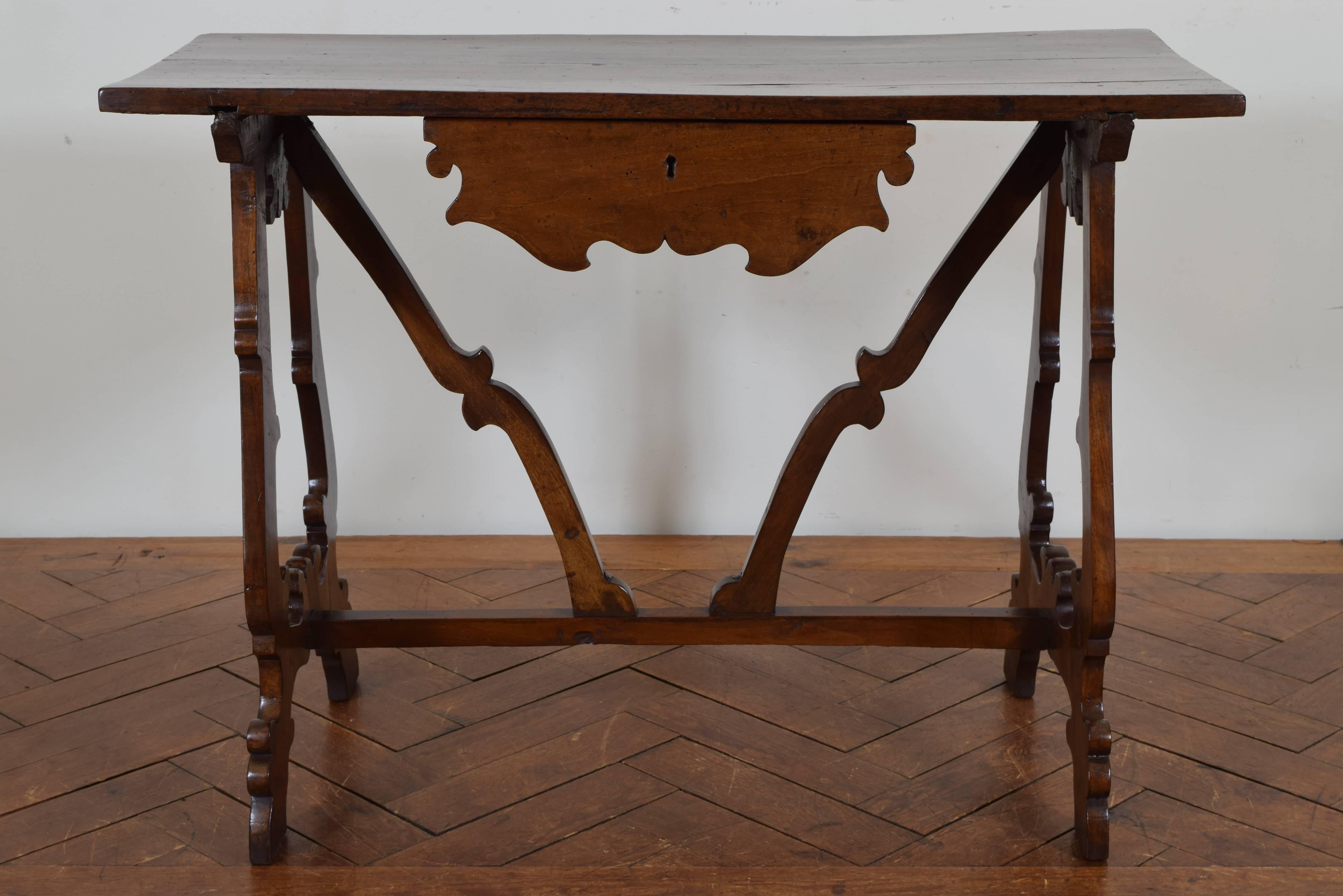 The rectangular top supporting one-drawer and side decorative carvings, raised on shaped lyre-form legs joined by three stretchers, late 17th century.