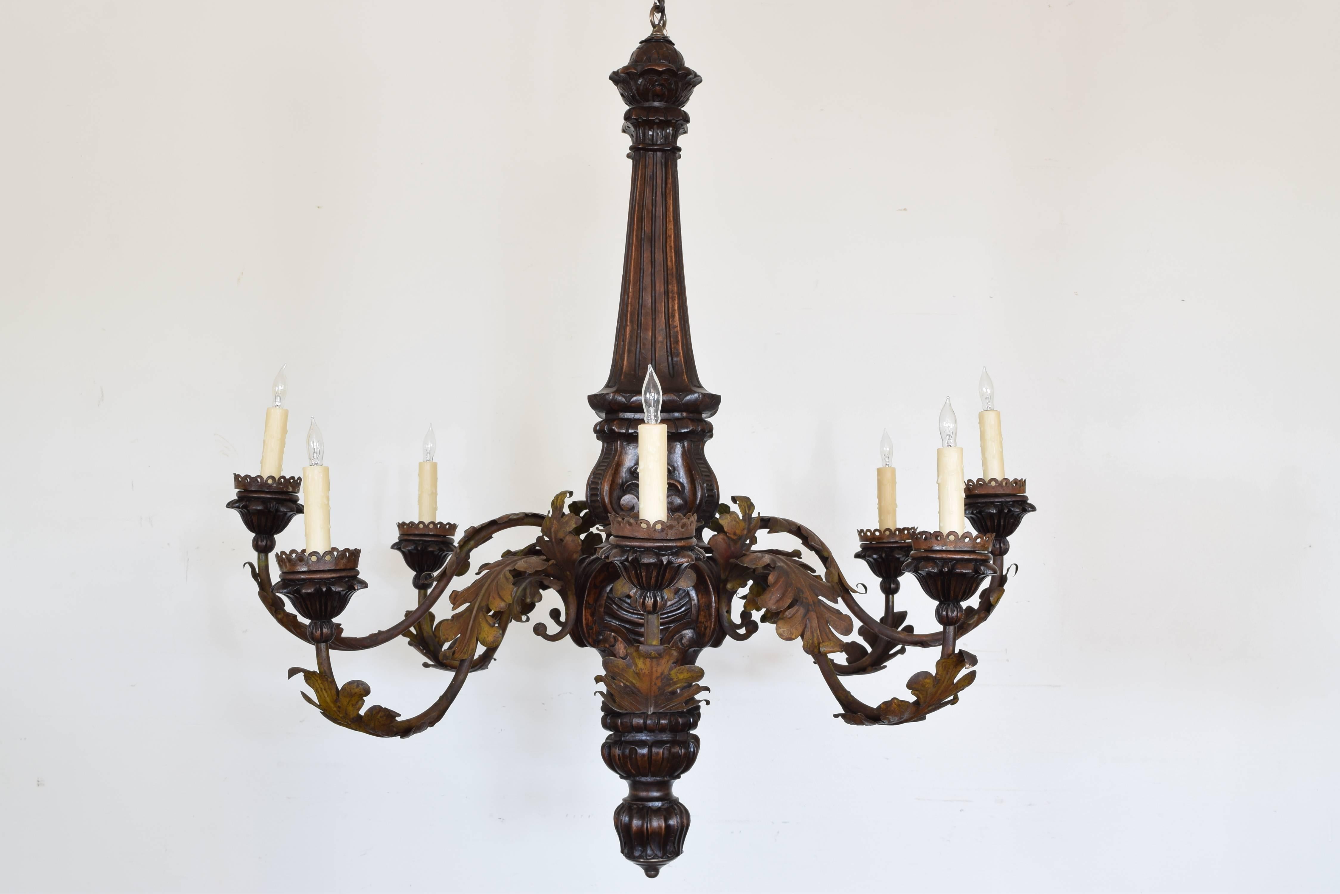 The fluted carved body issuing eight curved arms with painted metal leaves, bobeches also with fluted carving, UL Wired.