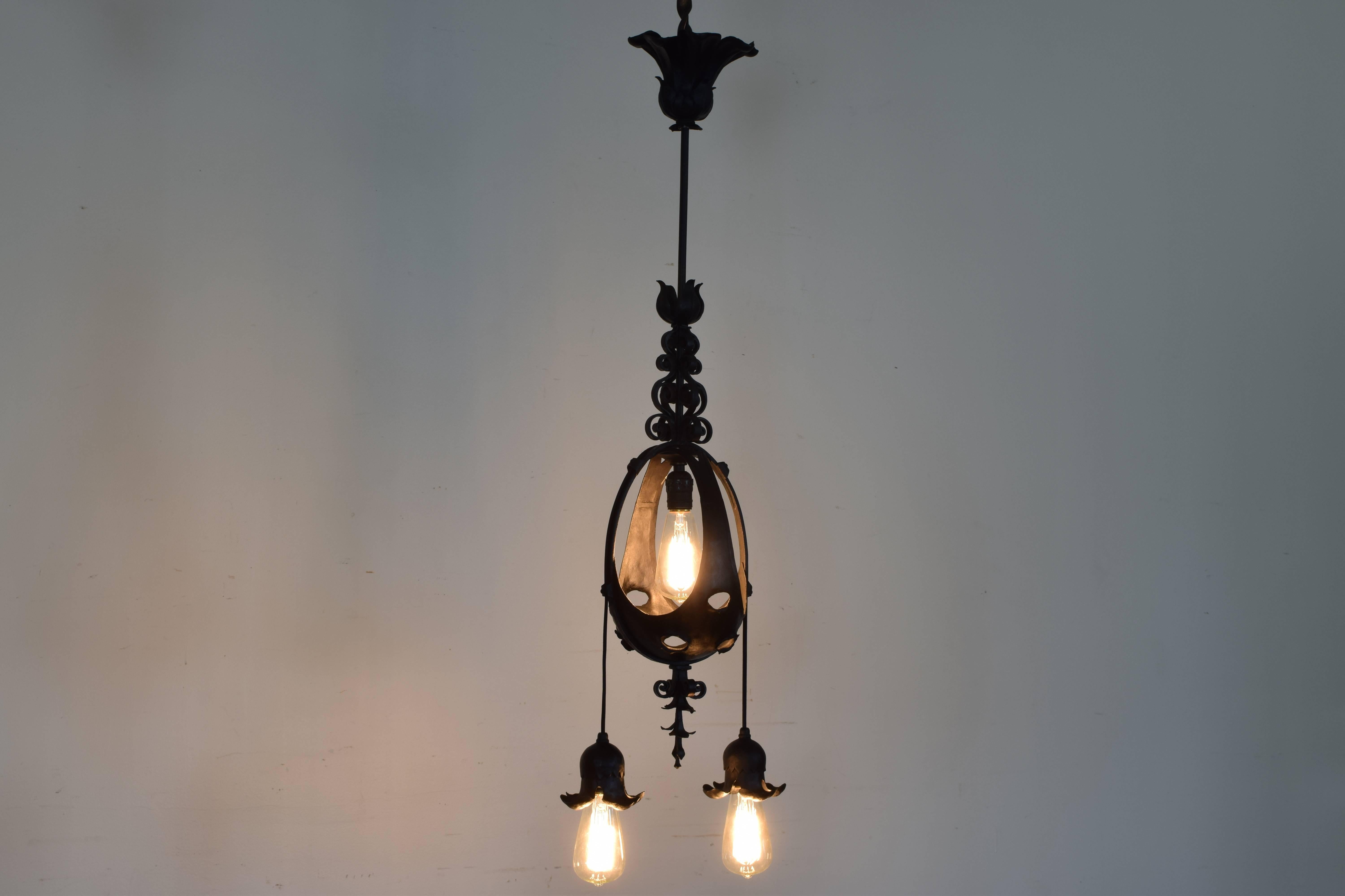 Italian, probably Milanese, wrought iron three-light orb chandelier, circa 1900. Of oval shape with pierced openings, with three down lights.