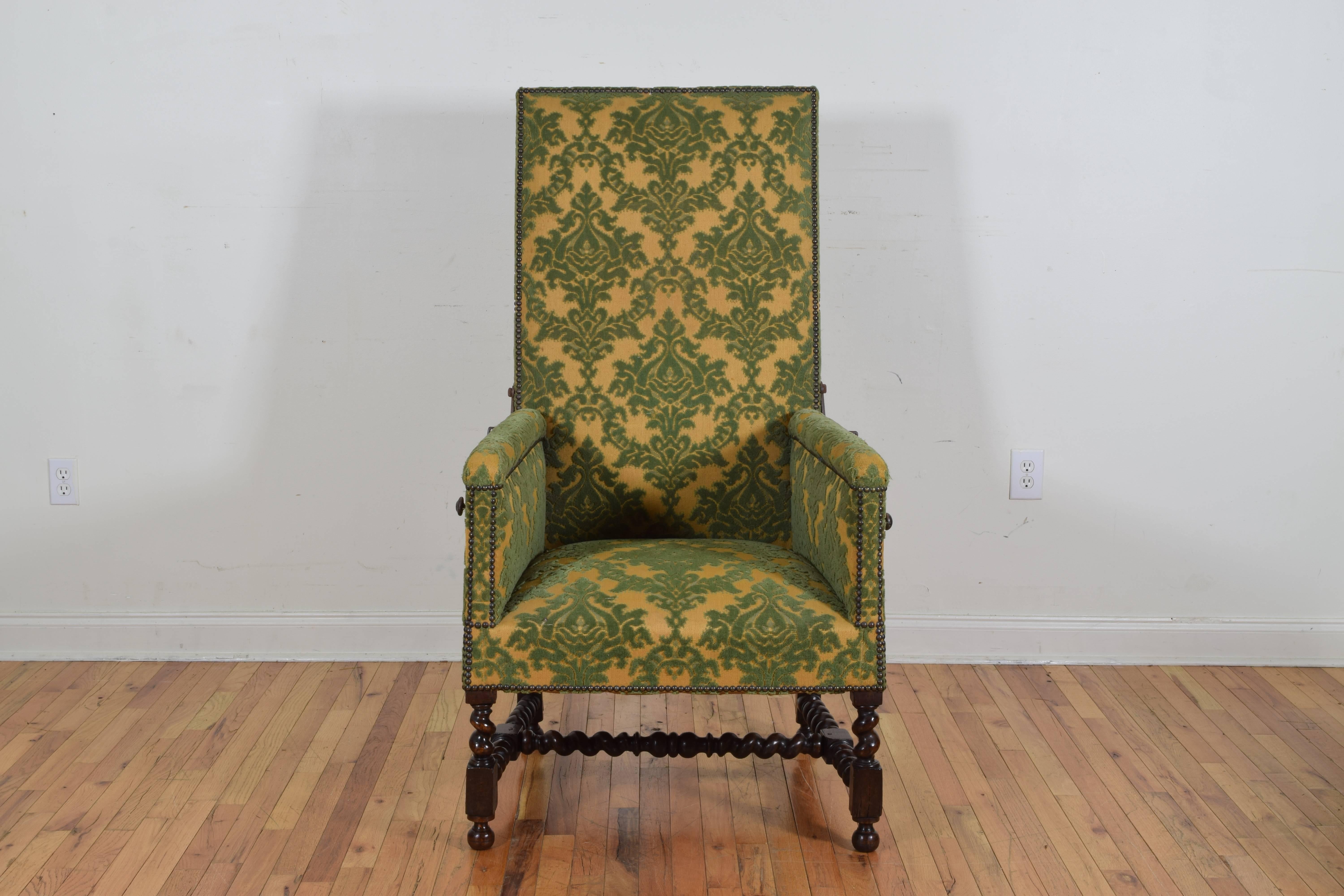 of larger scale and having a rectangular backrest, the frame with enclosed sides and a tight seat all upholstered in an antique velvet face damask, the side mounted iron ratchet adjustable to 8 positions, having splayed carved rear legs and spiral