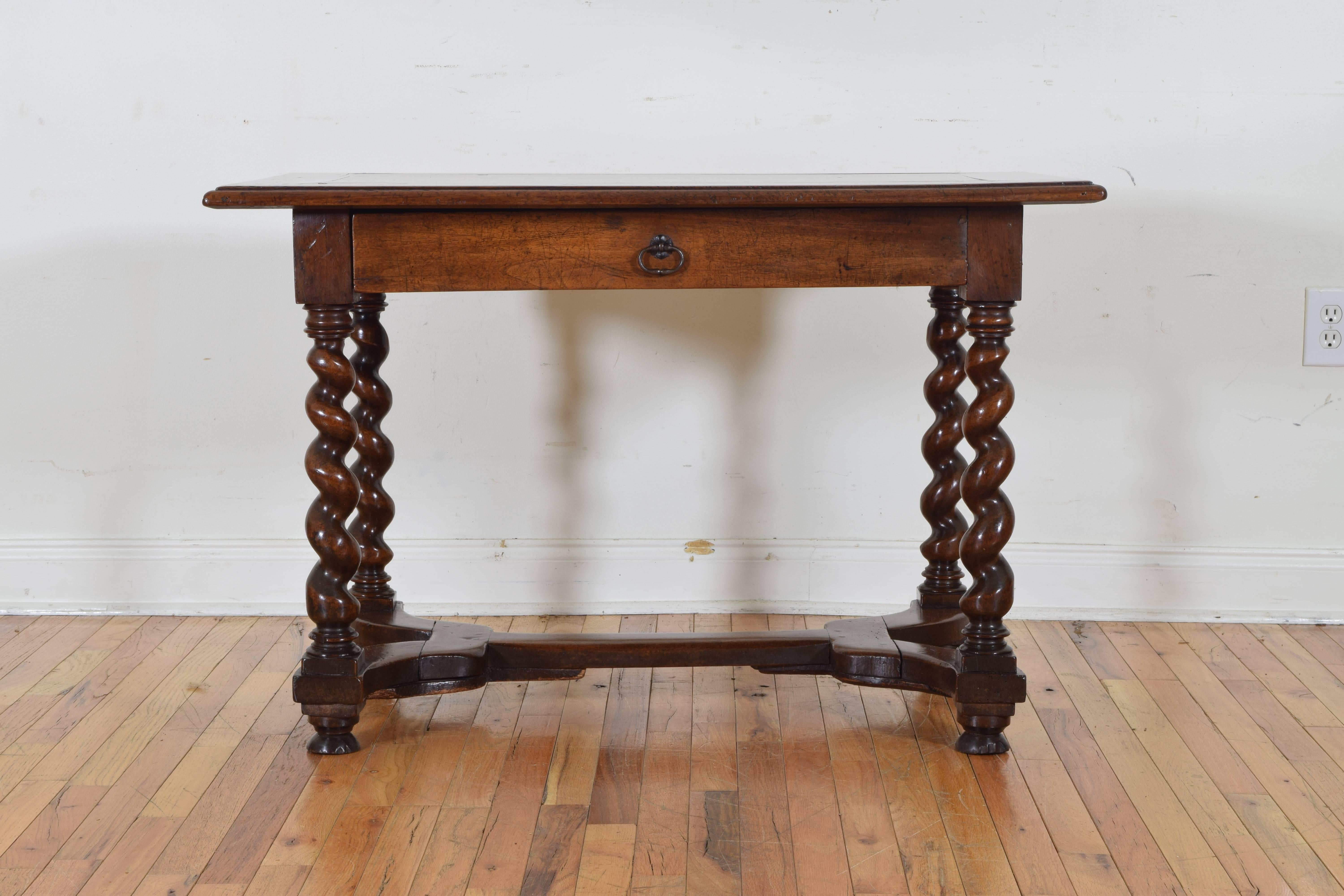 the rectangular top with framed and molded edges above case housing one drawer with an iron pull, raised on beautifully spiral turned legs joined by an elongated x-form stretcher, the stretcher atop half-bun feet
18th century