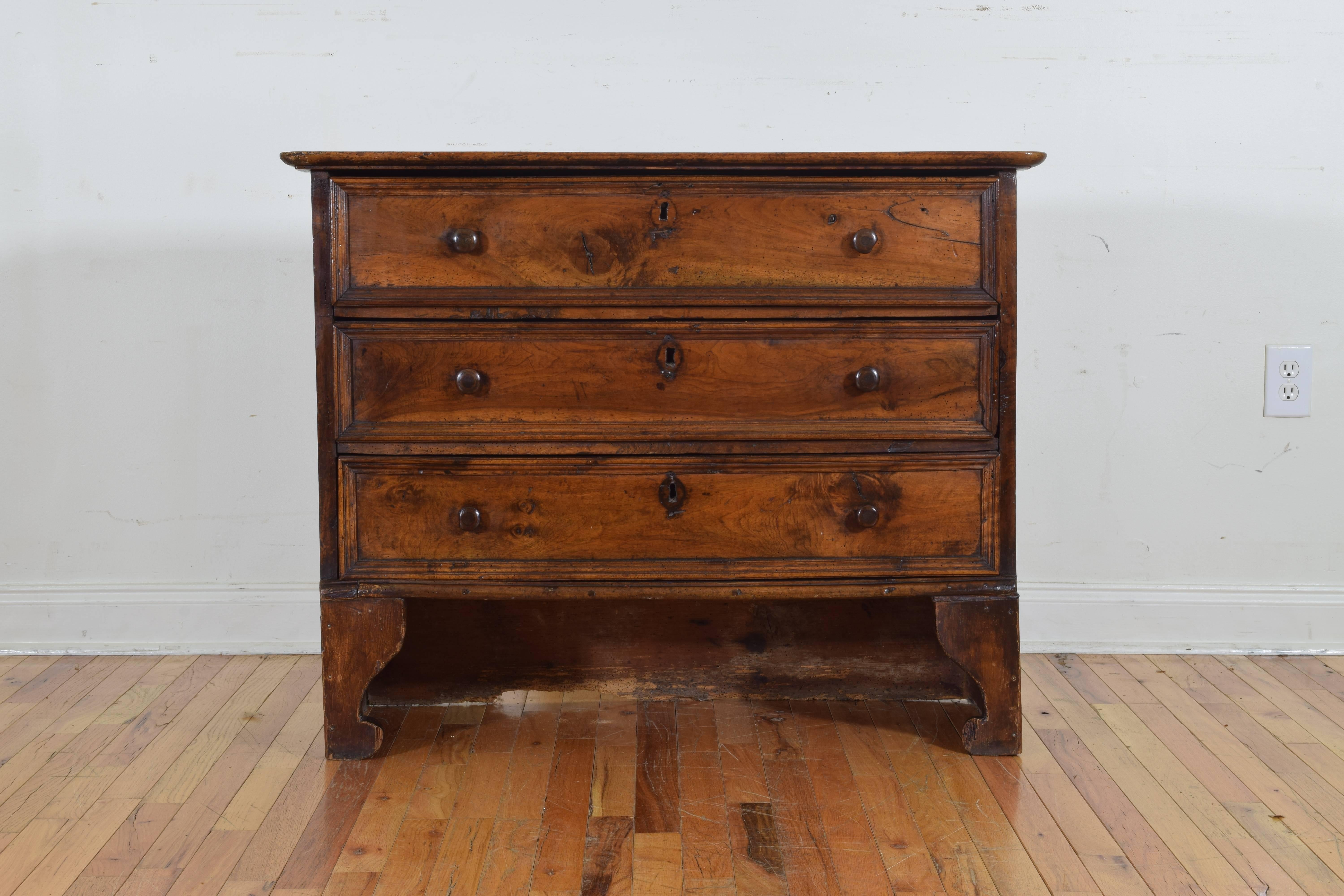 the rectangular top with a tapered edge above a conforming case housing 3 drawers with wooden pulls and molded edges, raised on interesting tall bracket feet, the bottom rear enclosed
17th/18th century