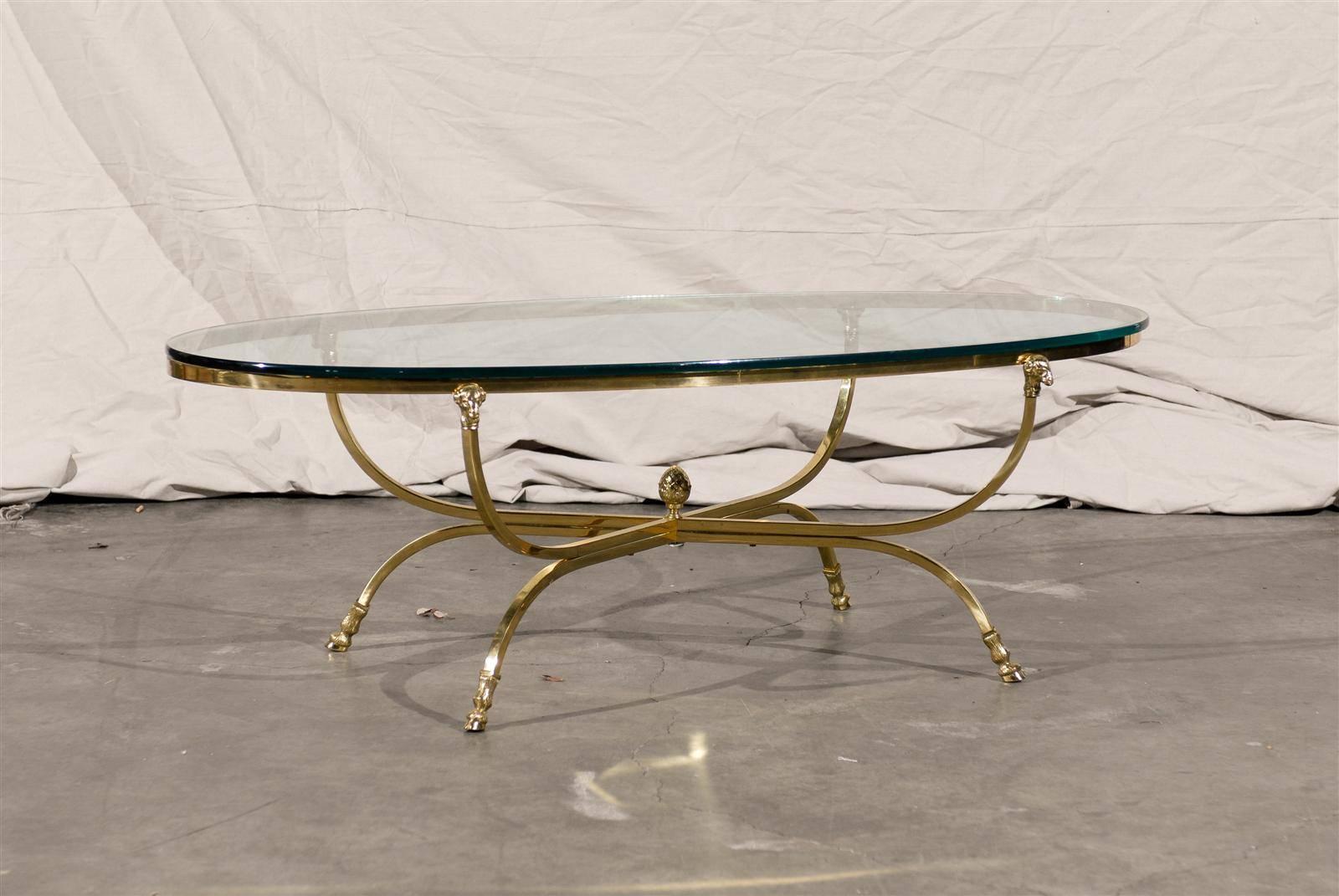 Mid-Century oval brass coffee table with glass top attributed to Maison Jansen.