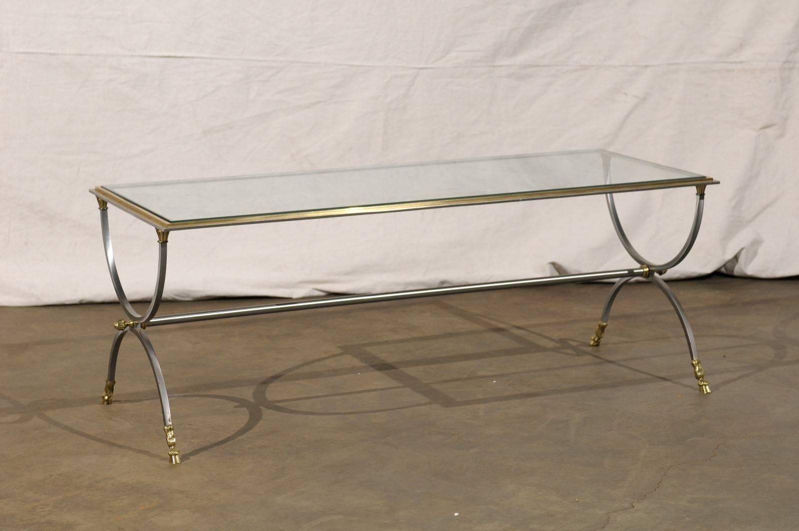 Baguès style glass top coffee table with hoof feet.