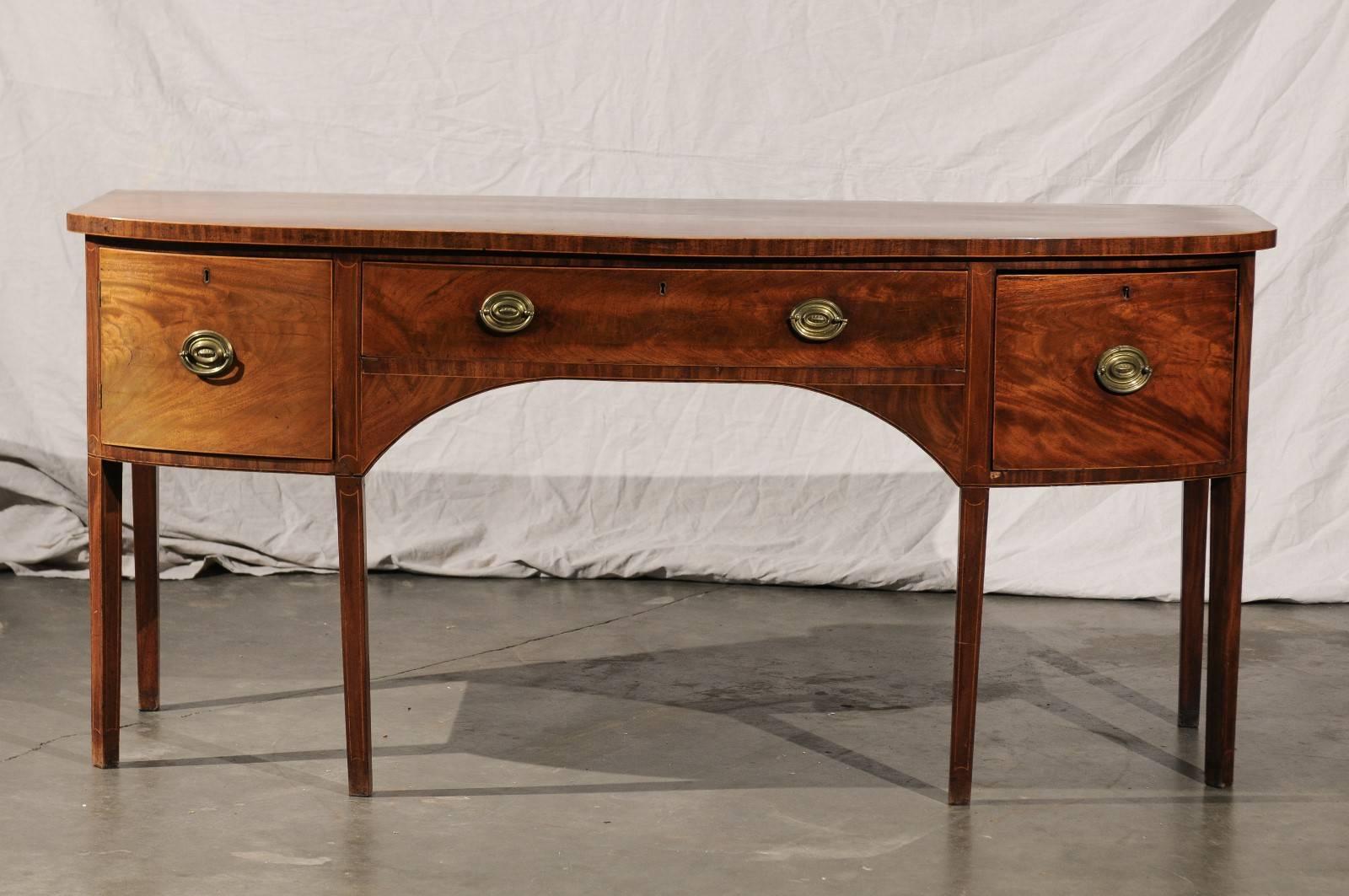 18th century, English George III bow front sideboard, faded figured mahogany with string inlay. Paper label- 15 king street.