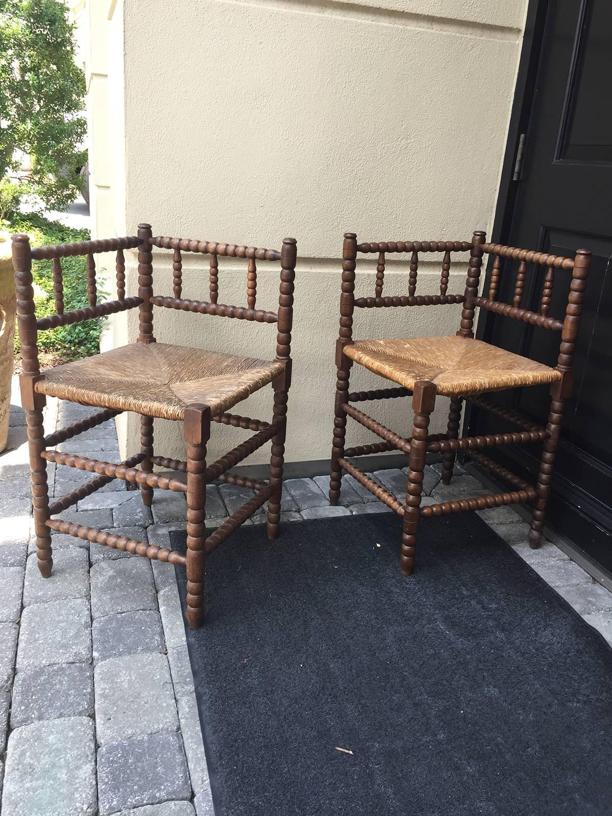 Pair of 19th century bobbin-turned stained beechwood rush seat corner chairs.