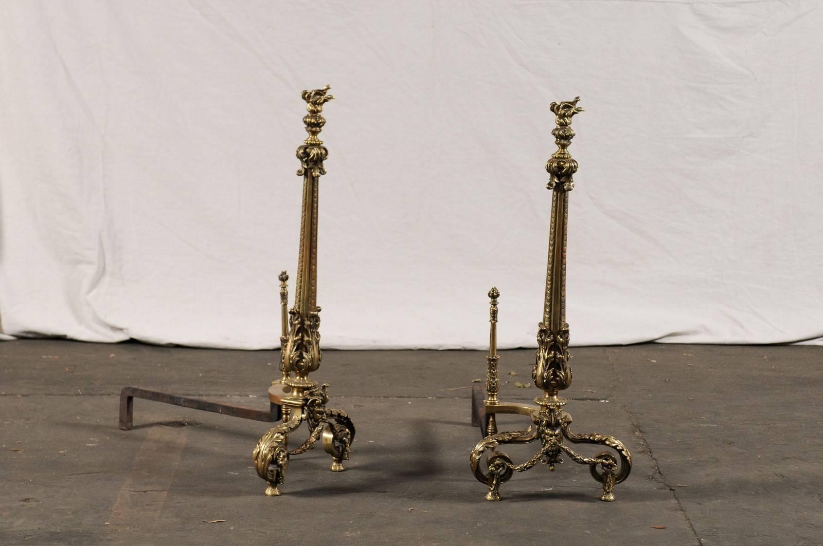 Stunning early 20th century bronze andirons with flame finials.