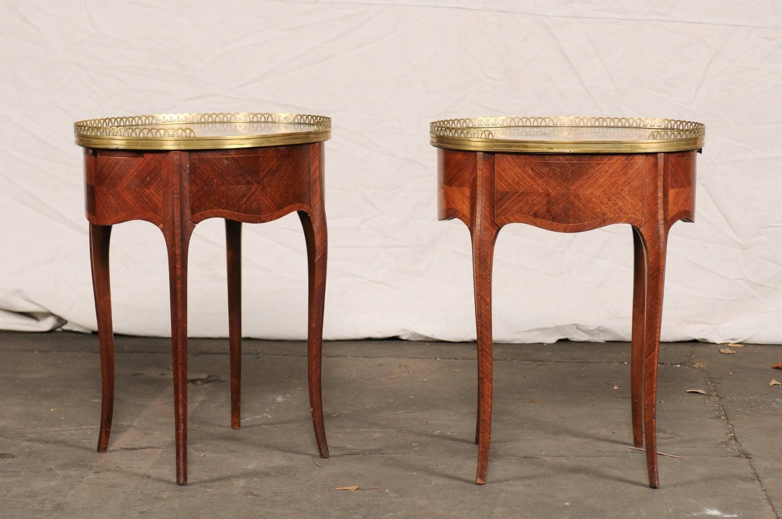 Pair of circa 1900 French marble-top, bronze gallery tables with drawers.