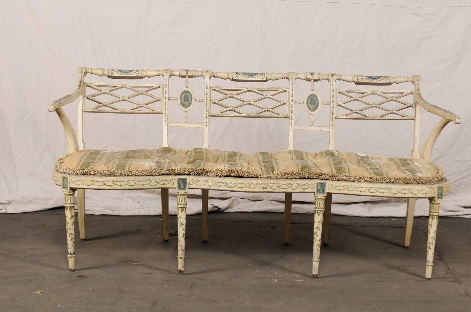 19th century English Sheraton painted decorated and caned settee, triple chair back design.