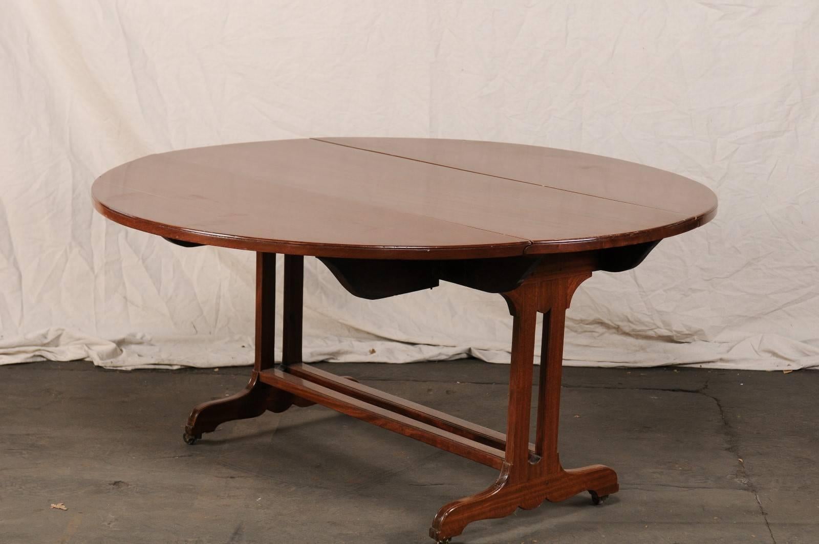Wood Late 19th Century Drop-Leaf Table, Trestle Form Base with Casters For Sale