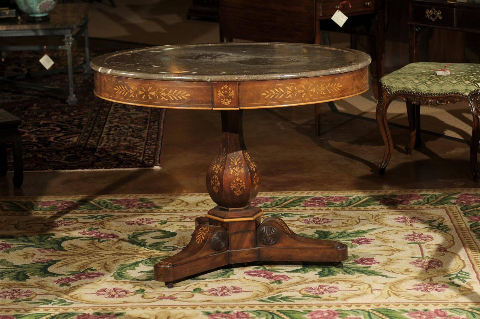 A very beautiful mahogany Charles X gueridon table with original multi brown and white veined marble-top. The table has marquetry inlay around the apron and the base. The top is supported by a pillar and tripod legs with inlay and carving.


